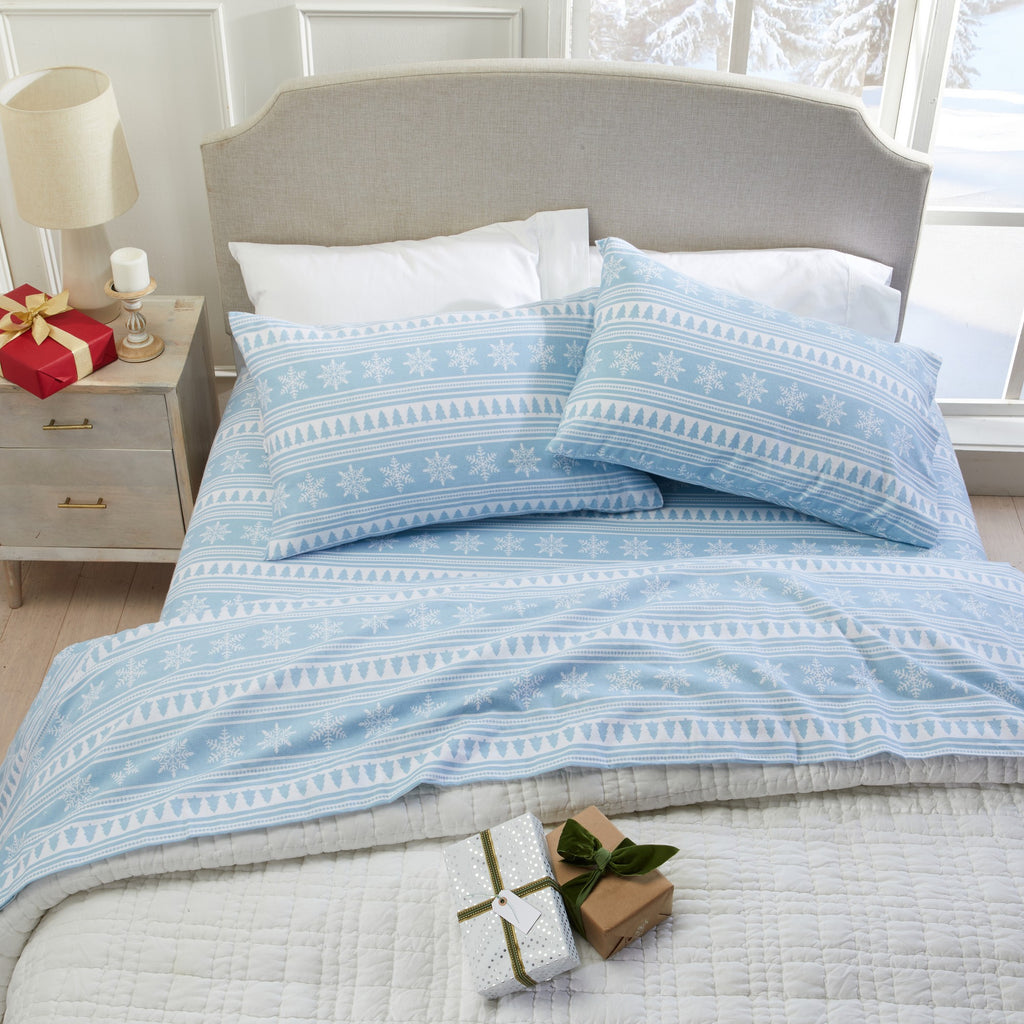 Printed 100% Turkish cotton flannel sheet set featuring assorted winter-inspired patterns, including woodland animals, snowflakes, trees, plaids, and seasonal motifs. Soft, cozy bedding shown in styled bedroom settings with close-up fabric details and folded sheet stacks in multiple designs.