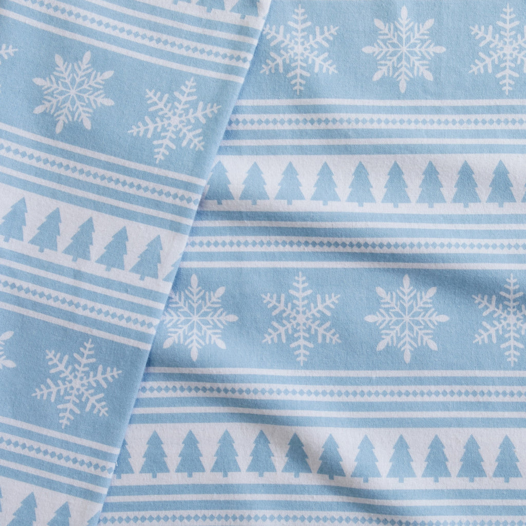Printed 100% Turkish cotton flannel sheet set featuring assorted winter-inspired patterns, including woodland animals, snowflakes, trees, plaids, and seasonal motifs. Soft, cozy bedding shown in styled bedroom settings with close-up fabric details and folded sheet stacks in multiple designs.