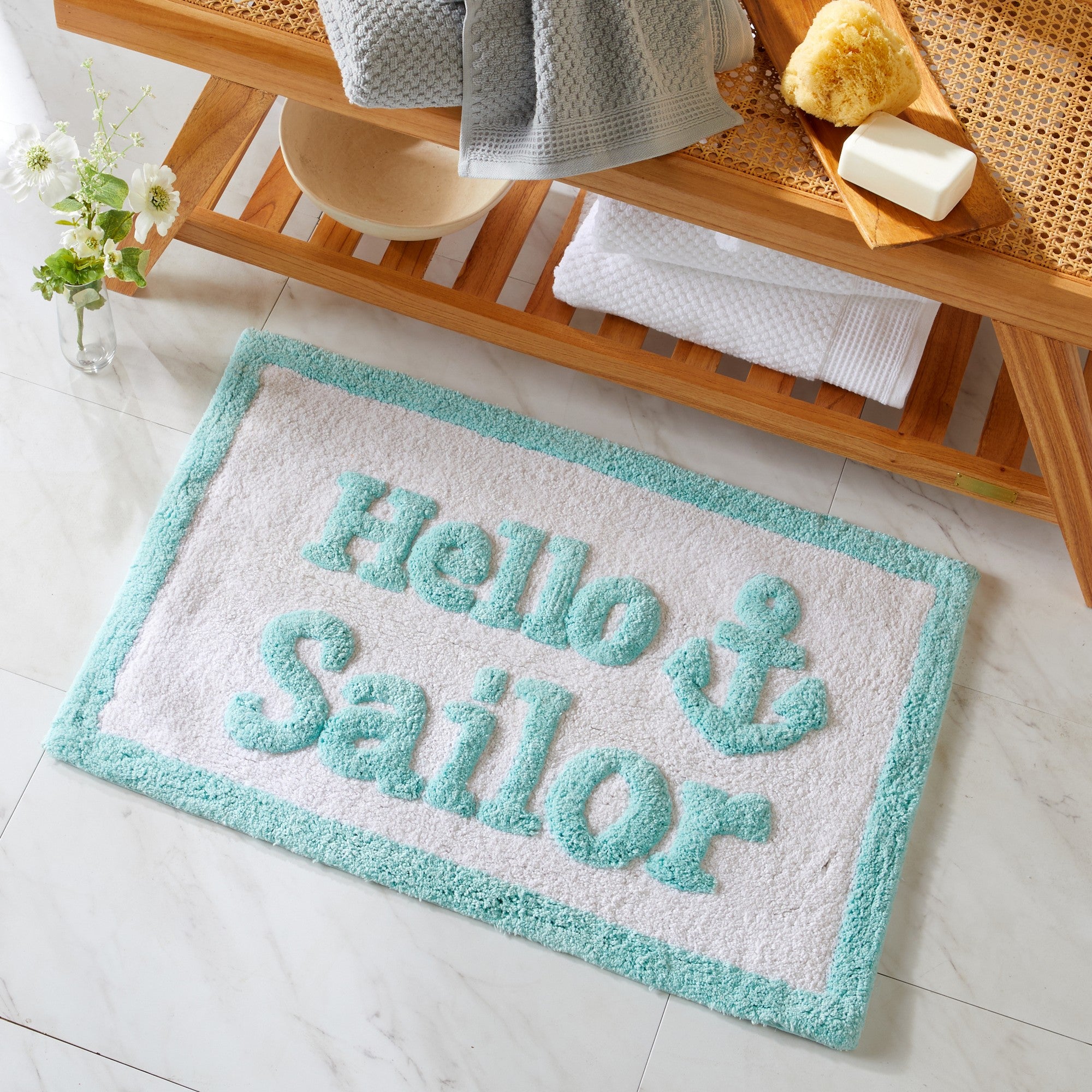 Doormat with 'Hello Sailor' text on a light wooden floor.