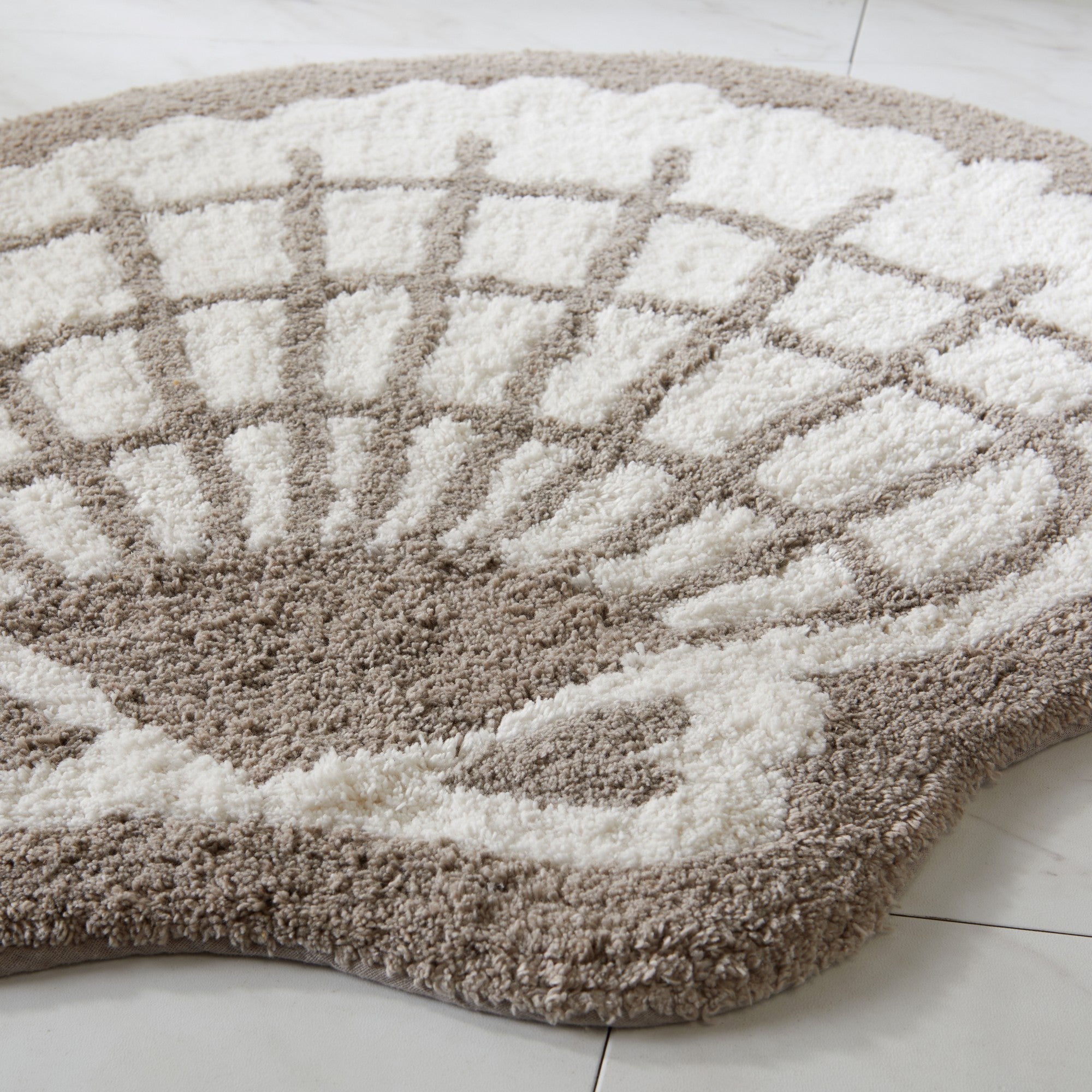 Round bath mat with geometric pattern on a white floor