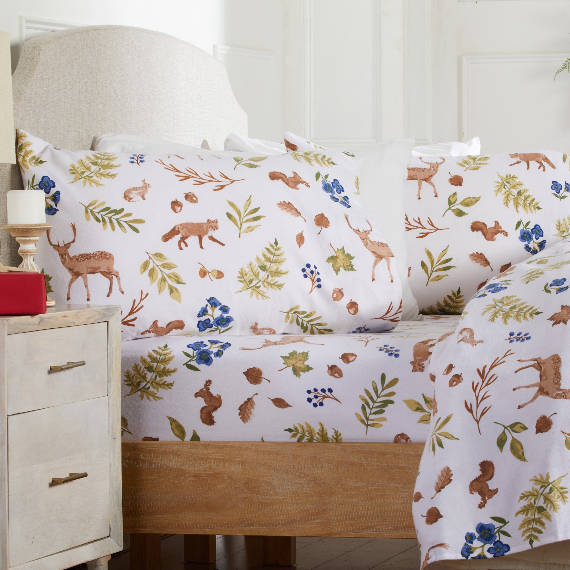 Bed with animal and nature patterned bedding in a bedroom setting.