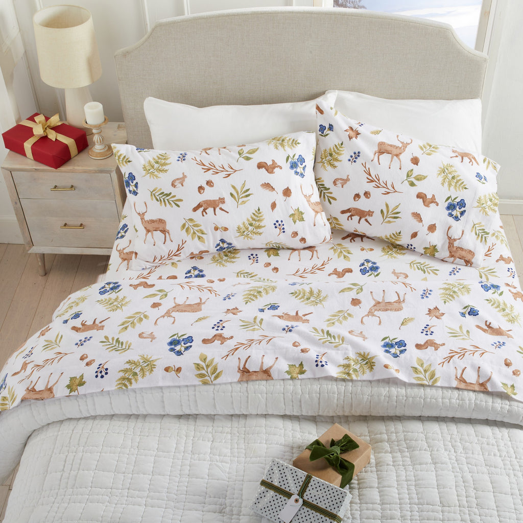 Floral and animal patterned bedding set on a bed with decorative items.