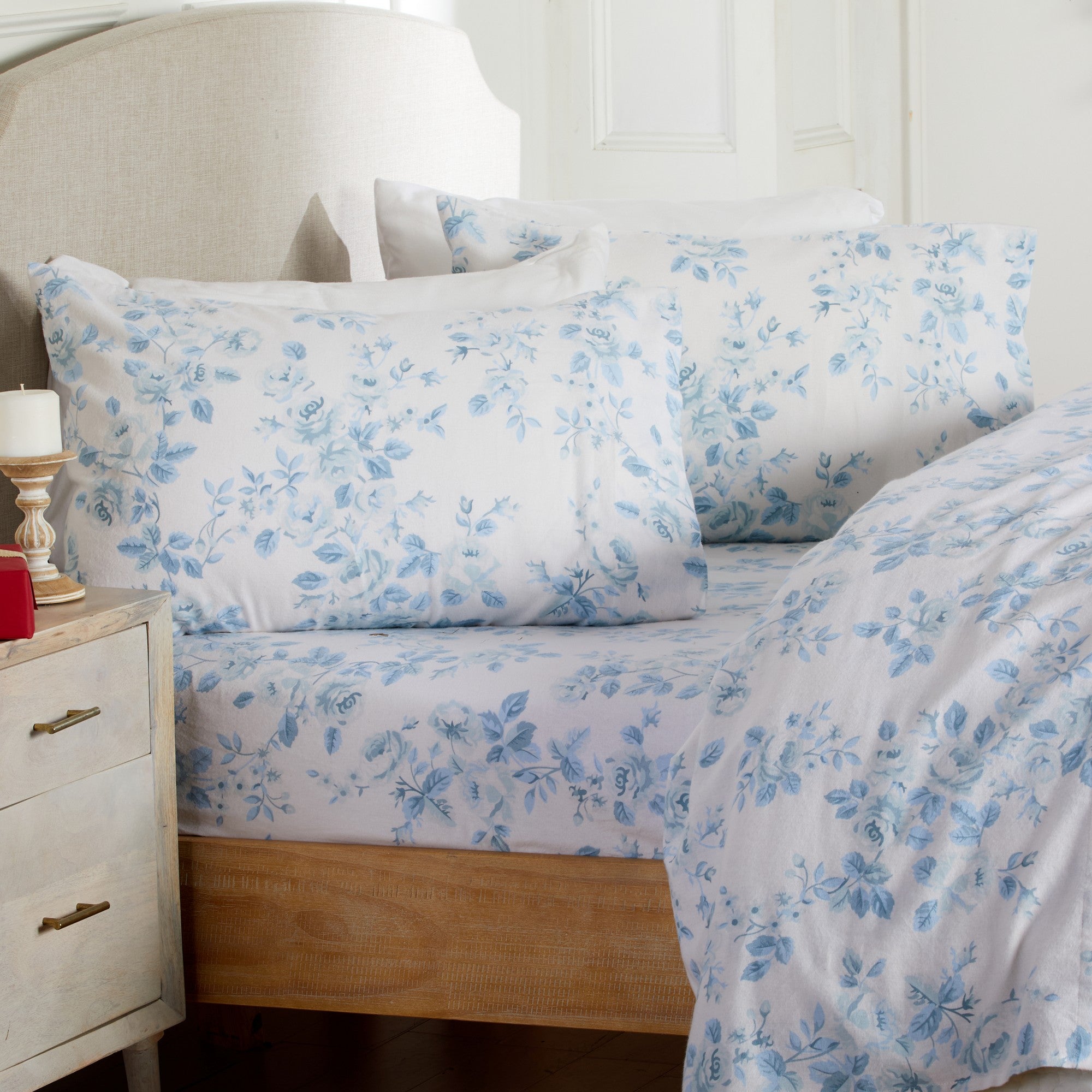 Floral bedding set on a bed with a nightstand in the background