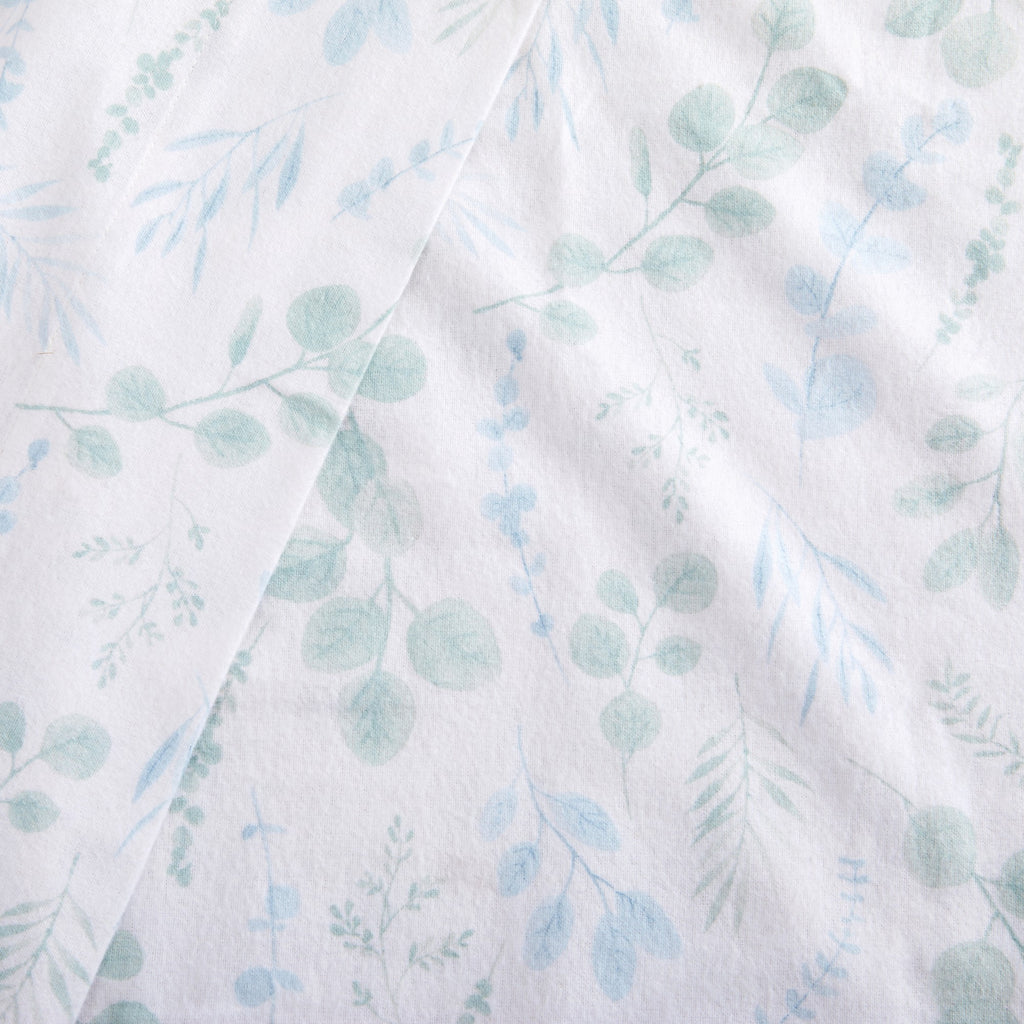 Fabric with a light blue and green leaf pattern on a white background