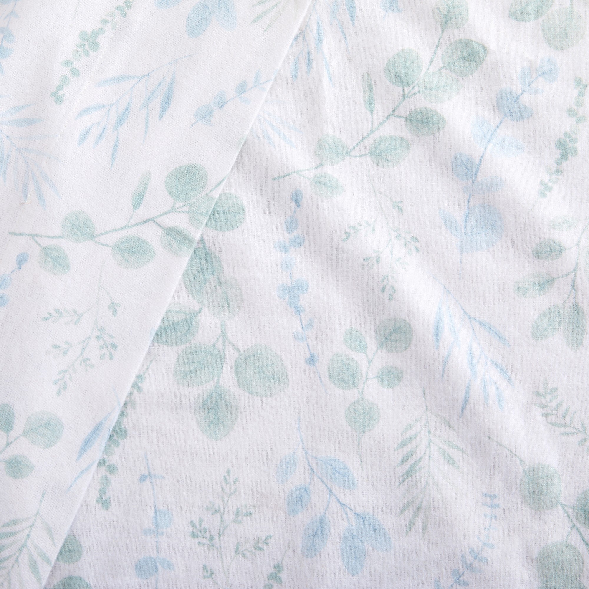 Fabric with a light blue and green leaf pattern on a white background