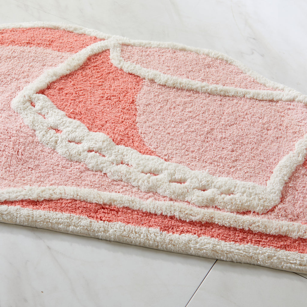 Pink and white textured rug on a light gray floor
