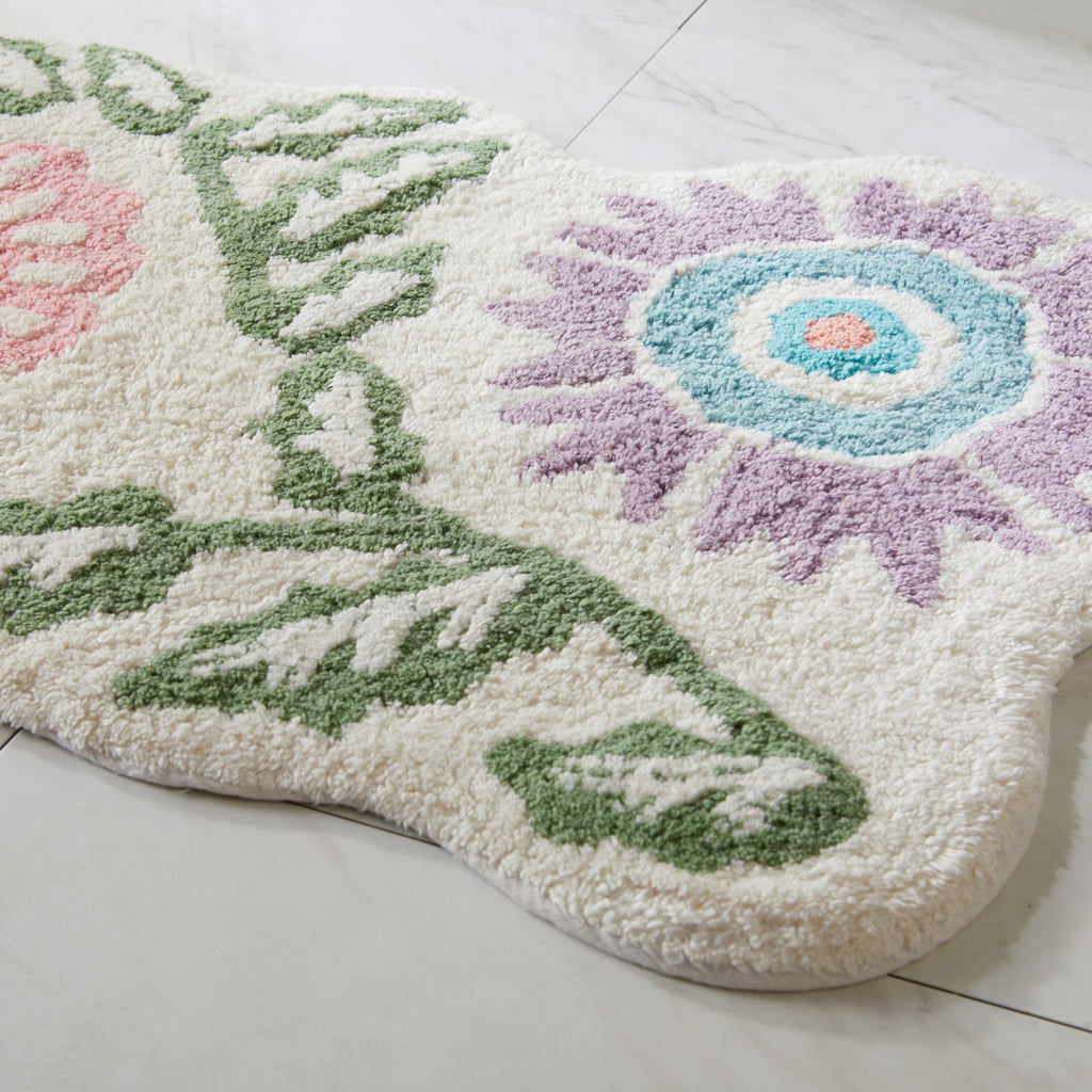 Decorative bath mat with floral design on a light wooden floor