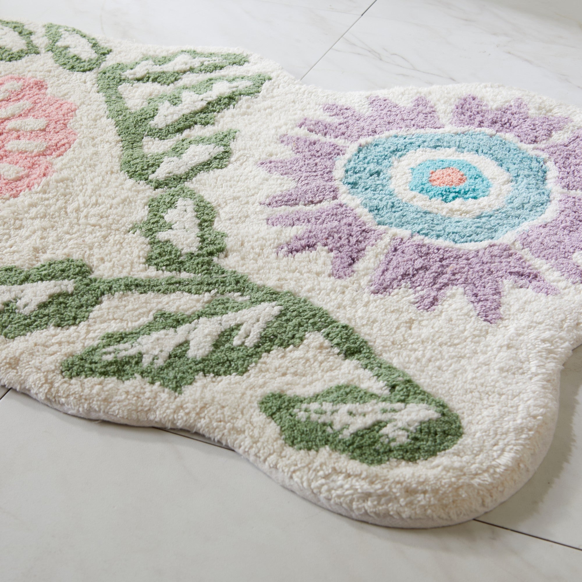 Decorative bath mat with floral design on a light wooden floor