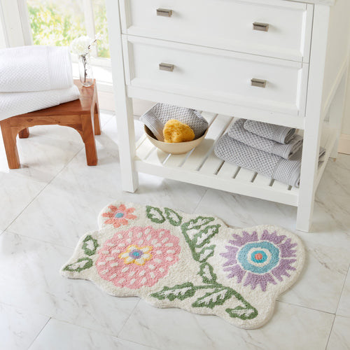 Floral cotton tufted bath rug on white tile bathroom floor