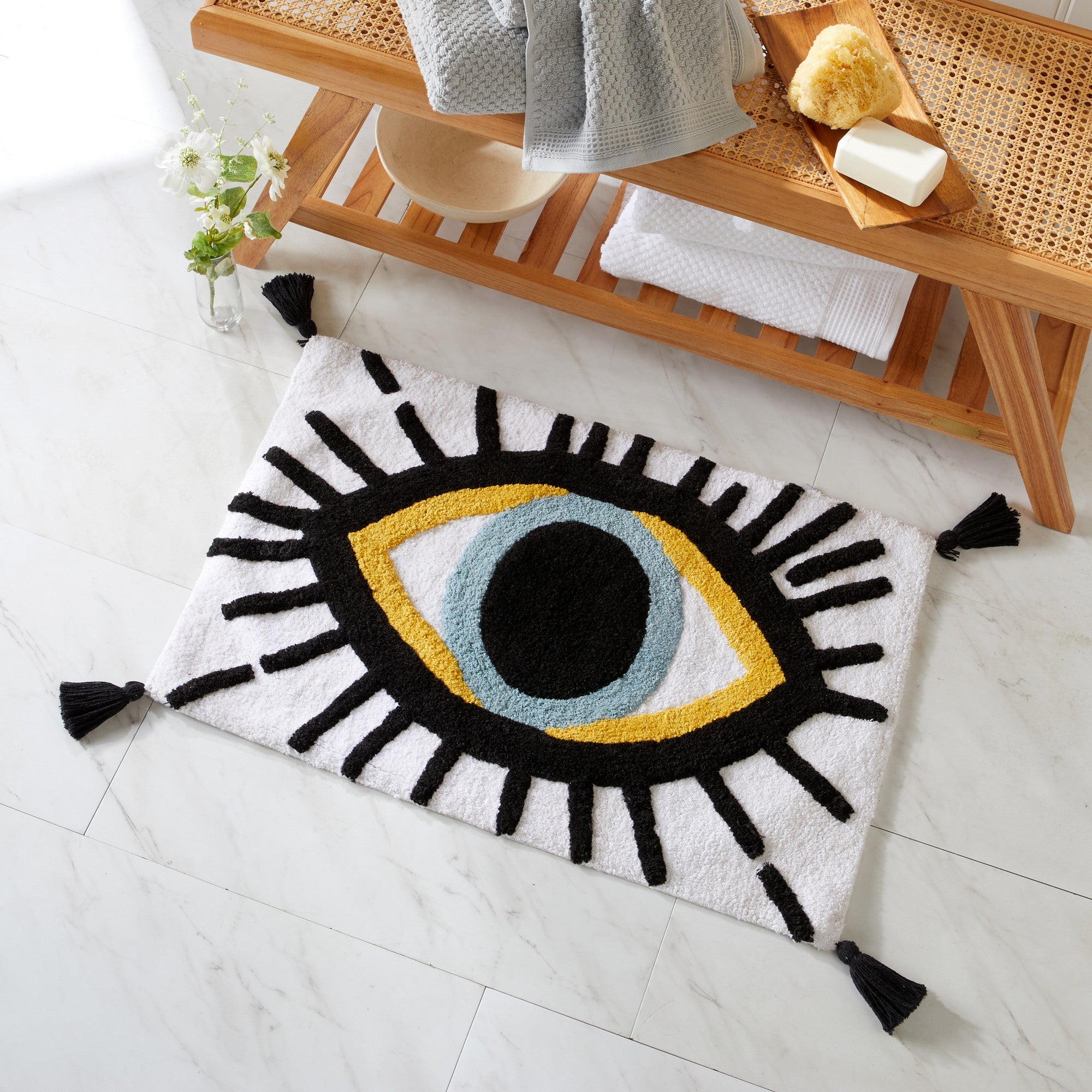 Decorative eye-shaped rug on a tiled floor with a wooden shelf in the background.