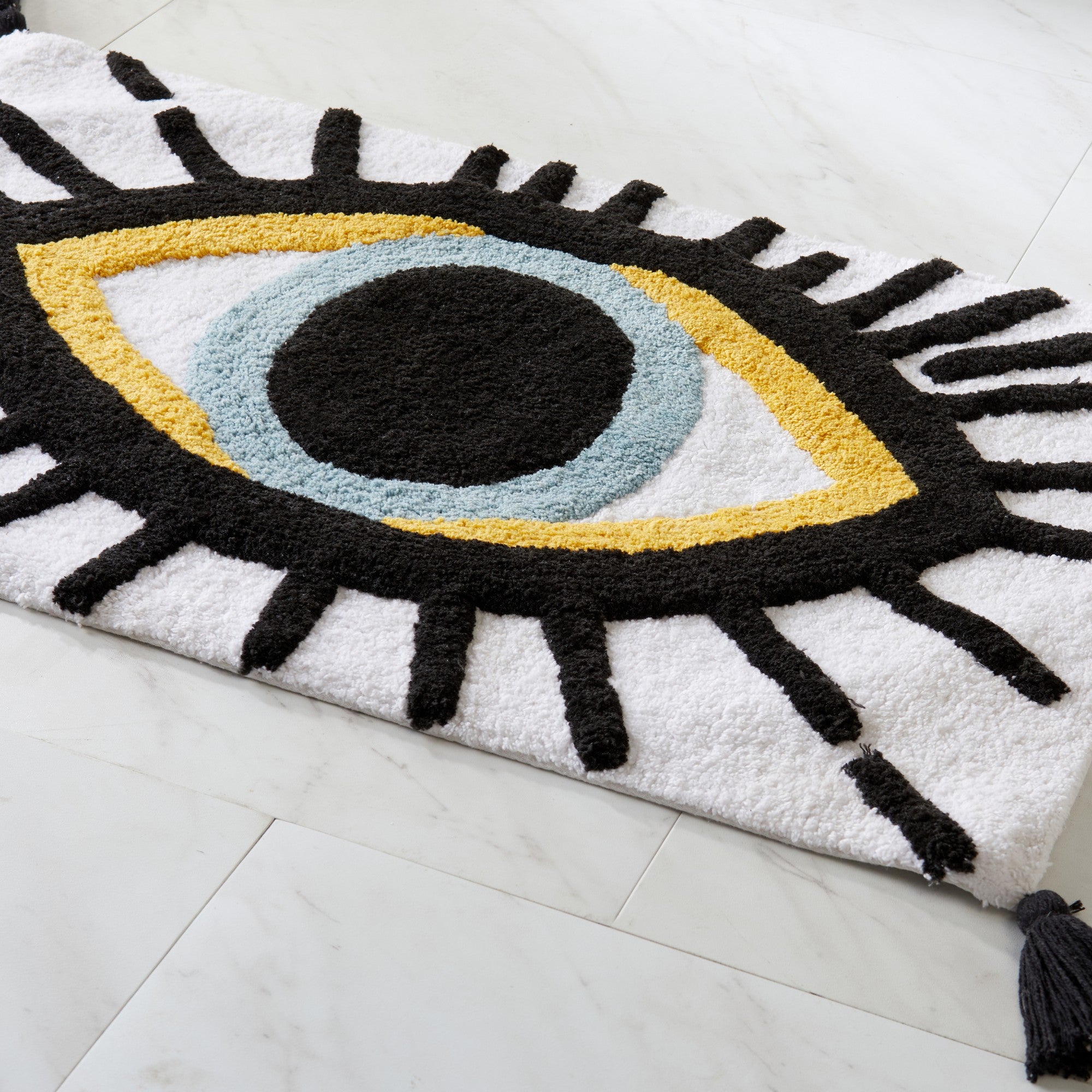 Decorative rug with eye design on a white floor