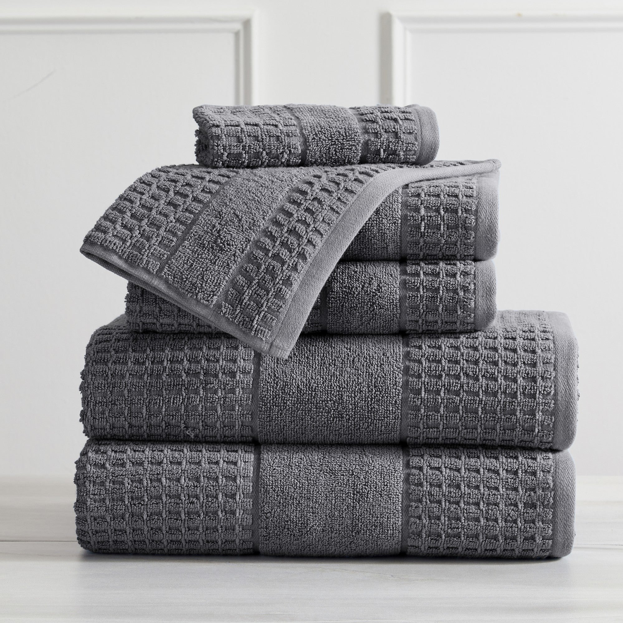 Harper Collection Waffle Textured Bath Towels by Market & Place featuring premium 100% cotton construction with a stylish waffle weave texture. Available in multiple colors and set configurations, including bath towels, hand towels, and washcloths, shown folded, stacked, and styled to highlight their soft, plush, and highly absorbent design.