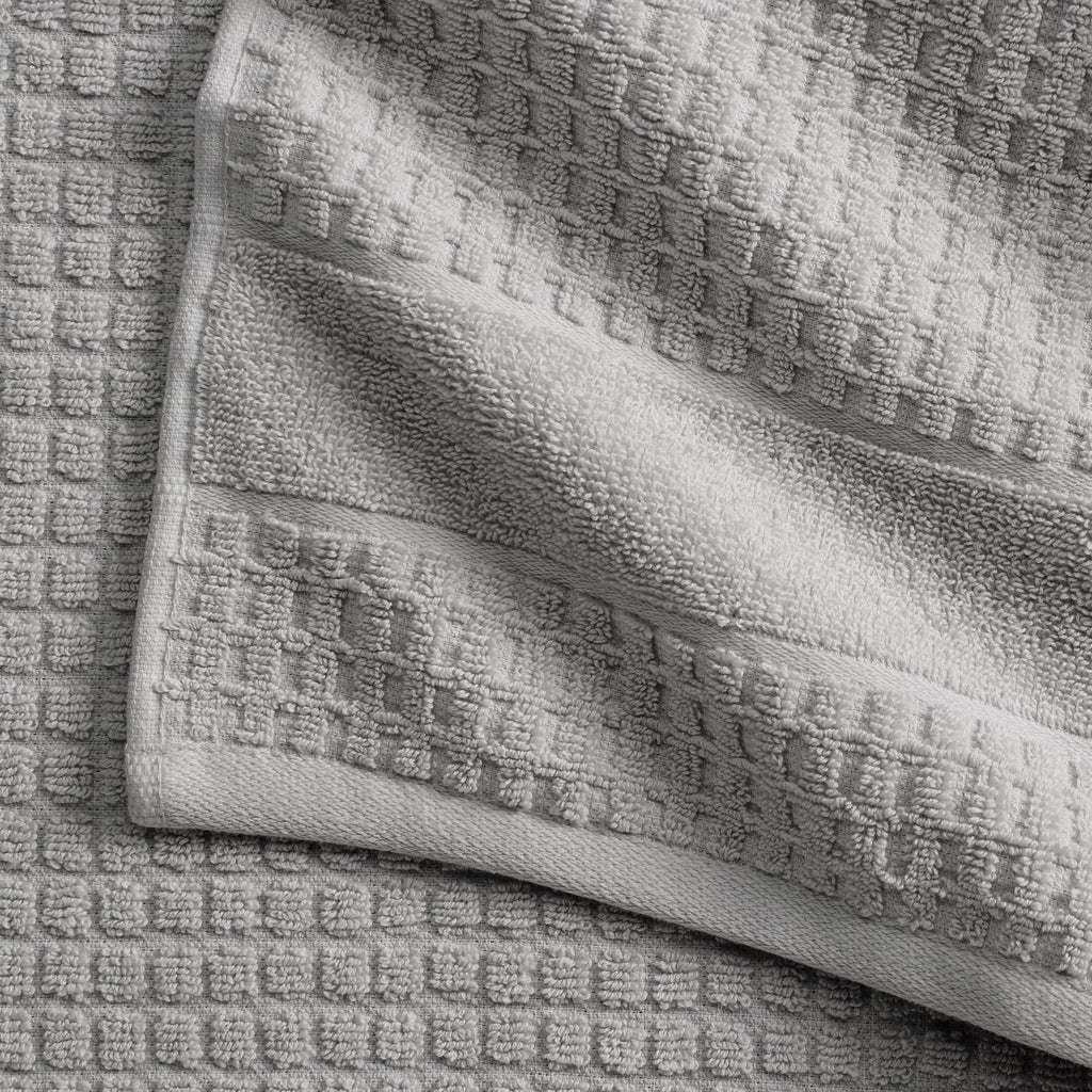 Harper Collection Waffle Textured Bath Towels by Market & Place featuring premium 100% cotton construction with a stylish waffle weave texture. Available in multiple colors and set configurations, including bath towels, hand towels, and washcloths, shown folded, stacked, and styled to highlight their soft, plush, and highly absorbent design.