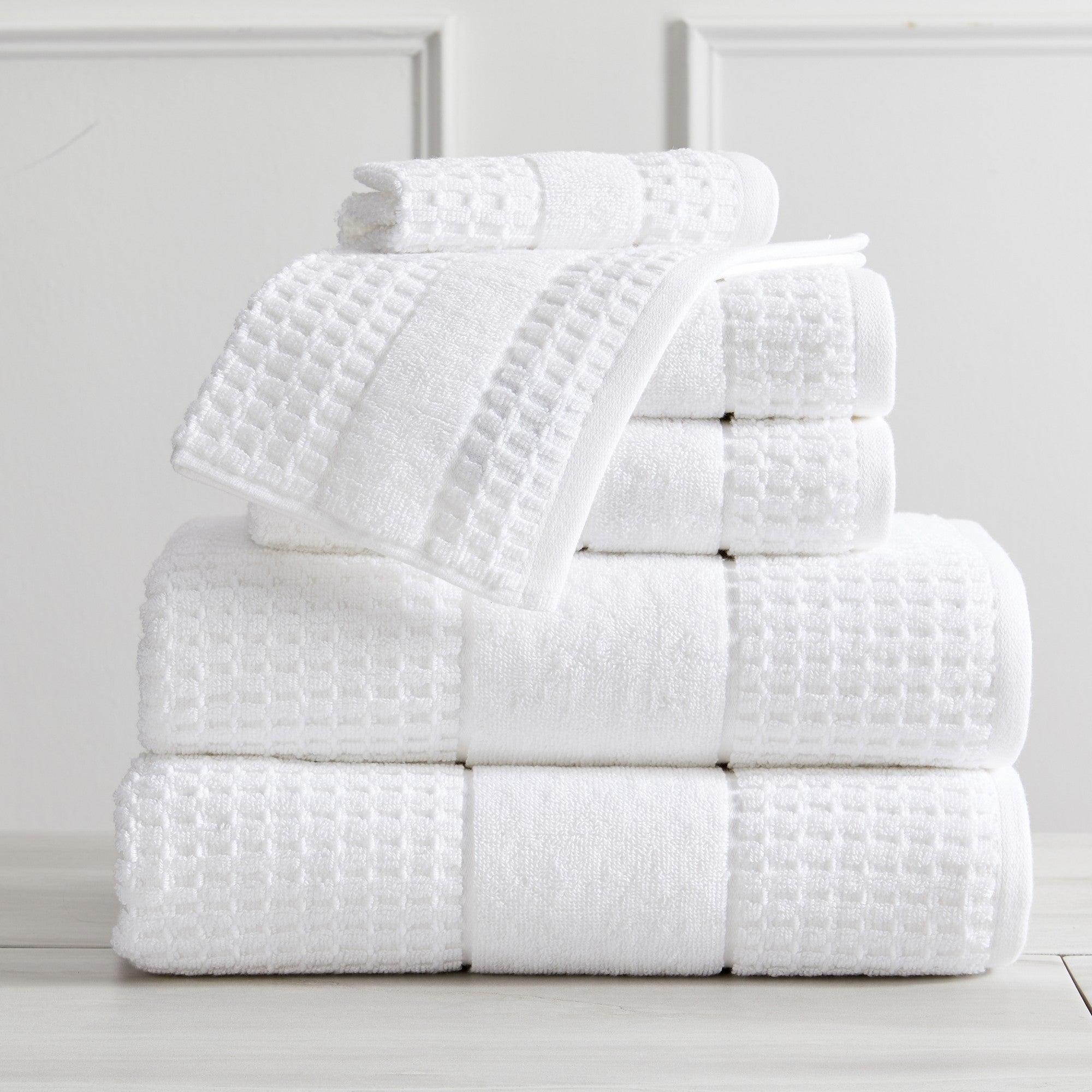 Harper Collection Waffle Textured Bath Towels by Market & Place featuring premium 100% cotton construction with a stylish waffle weave texture. Available in multiple colors and set configurations, including bath towels, hand towels, and washcloths, shown folded, stacked, and styled to highlight their soft, plush, and highly absorbent design.