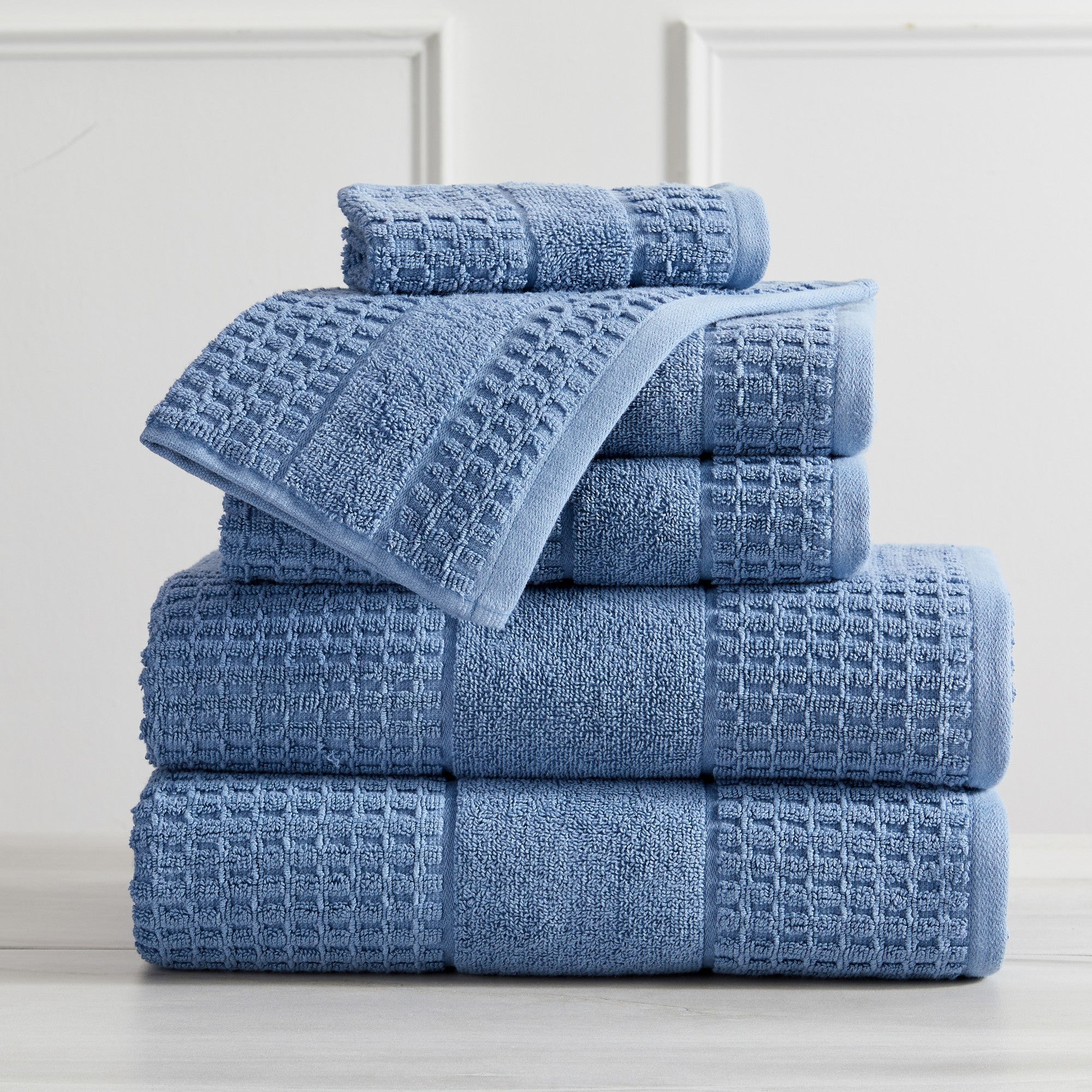 Harper Collection Waffle Textured Bath Towels by Market & Place featuring premium 100% cotton construction with a stylish waffle weave texture. Available in multiple colors and set configurations, including bath towels, hand towels, and washcloths, shown folded, stacked, and styled to highlight their soft, plush, and highly absorbent design.