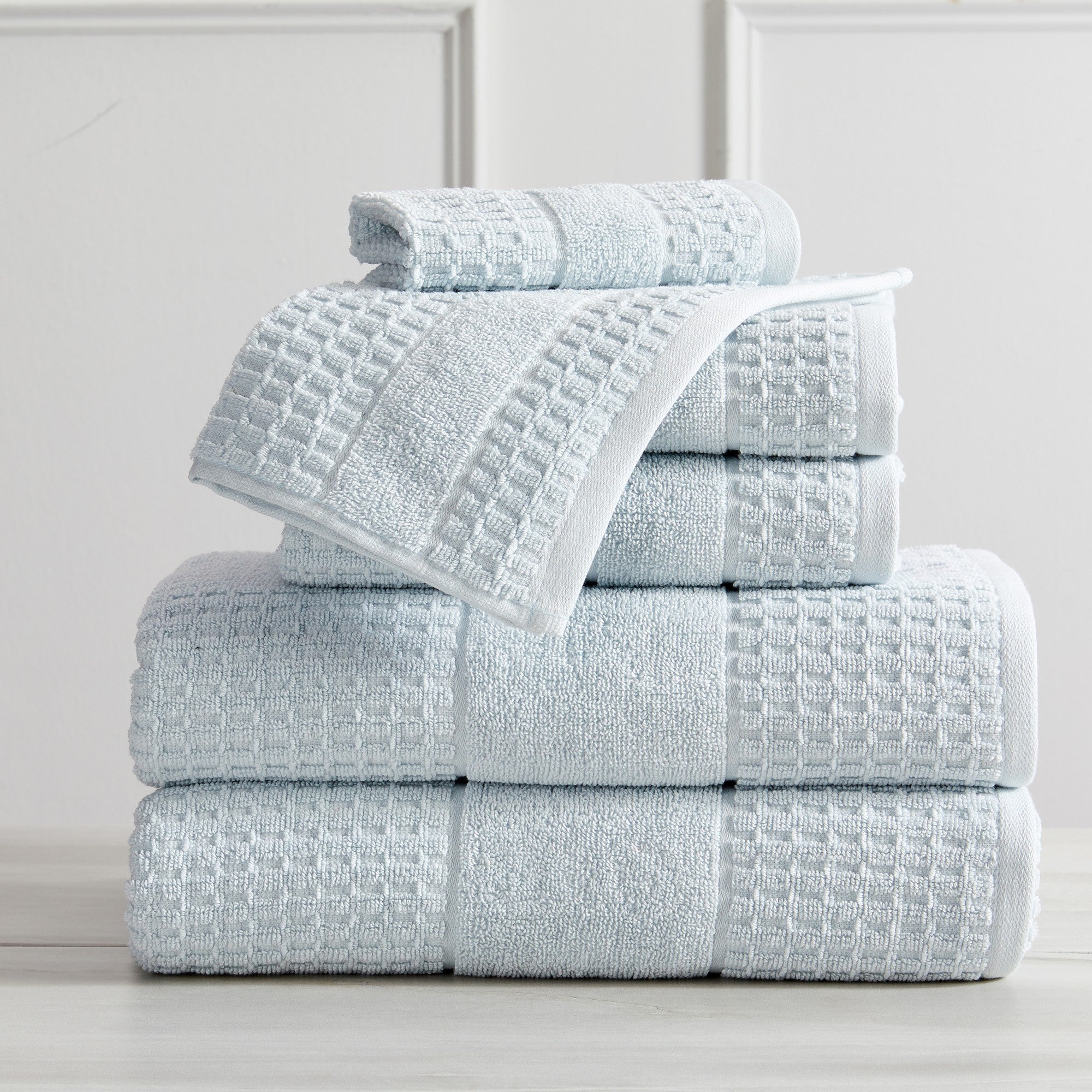 Harper Collection Waffle Textured Bath Towels by Market & Place featuring premium 100% cotton construction with a stylish waffle weave texture. Available in multiple colors and set configurations, including bath towels, hand towels, and washcloths, shown folded, stacked, and styled to highlight their soft, plush, and highly absorbent design.