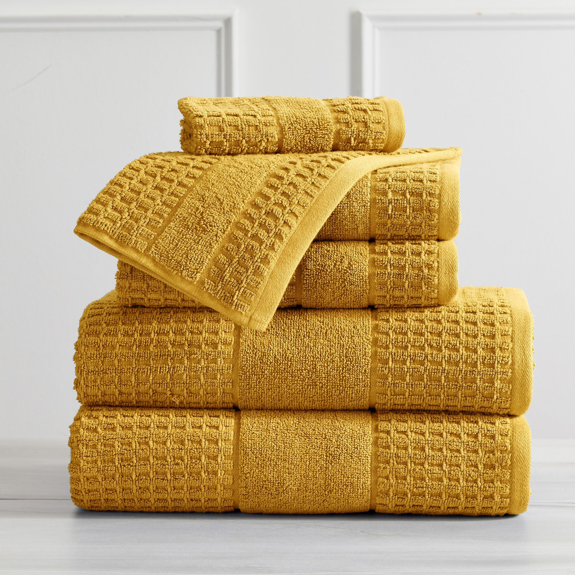 Harper Collection Waffle Textured Bath Towels by Market & Place featuring premium 100% cotton construction with a stylish waffle weave texture. Available in multiple colors and set configurations, including bath towels, hand towels, and washcloths, shown folded, stacked, and styled to highlight their soft, plush, and highly absorbent design.