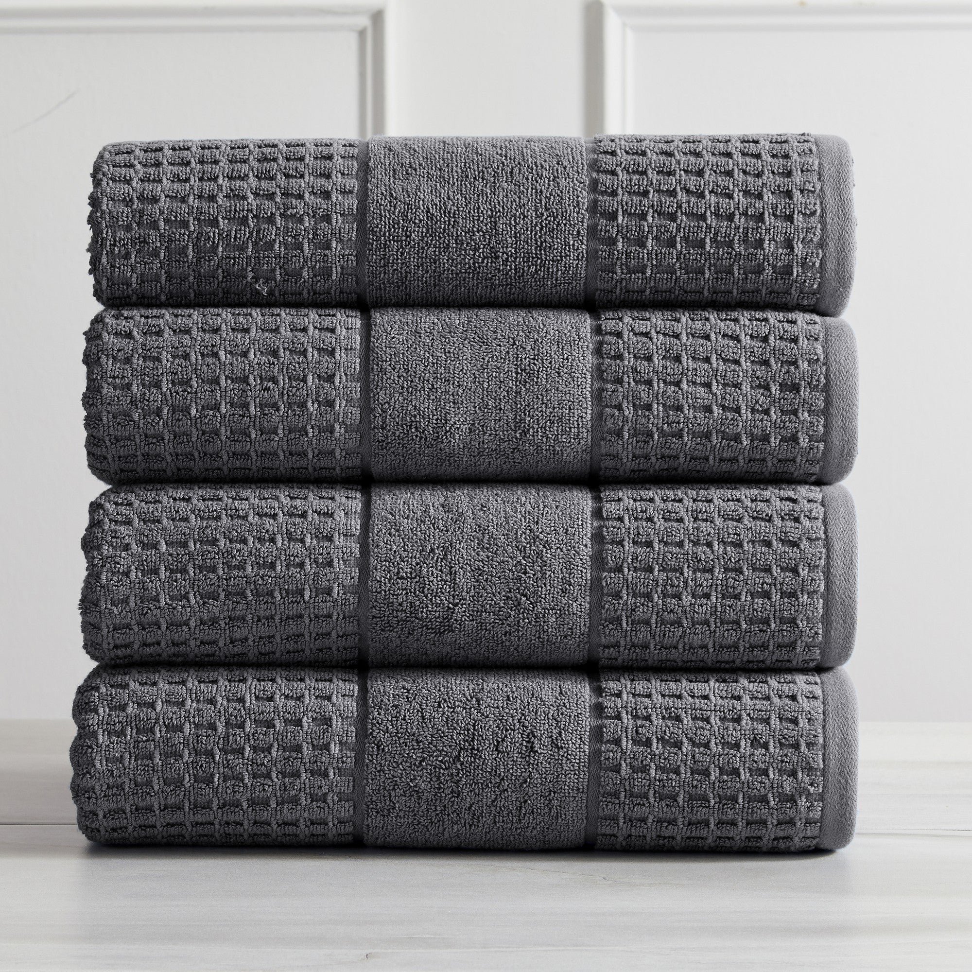 Harper Collection Waffle Textured Bath Towels by Market & Place featuring premium 100% cotton construction with a stylish waffle weave texture. Available in multiple colors and set configurations, including bath towels, hand towels, and washcloths, shown folded, stacked, and styled to highlight their soft, plush, and highly absorbent design.