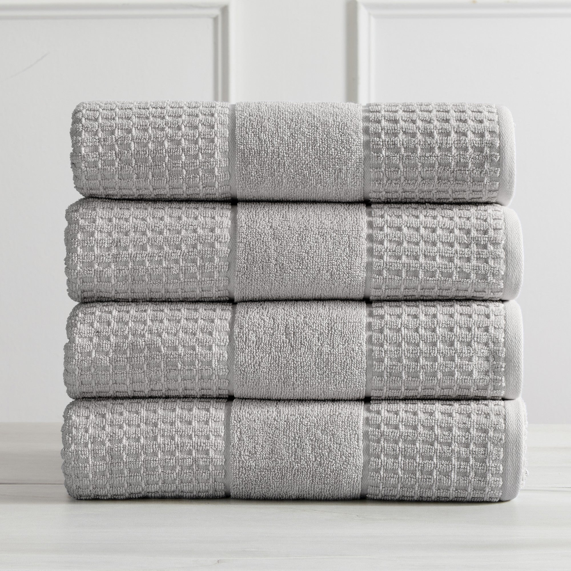 Harper Collection Waffle Textured Bath Towels by Market & Place featuring premium 100% cotton construction with a stylish waffle weave texture. Available in multiple colors and set configurations, including bath towels, hand towels, and washcloths, shown folded, stacked, and styled to highlight their soft, plush, and highly absorbent design.