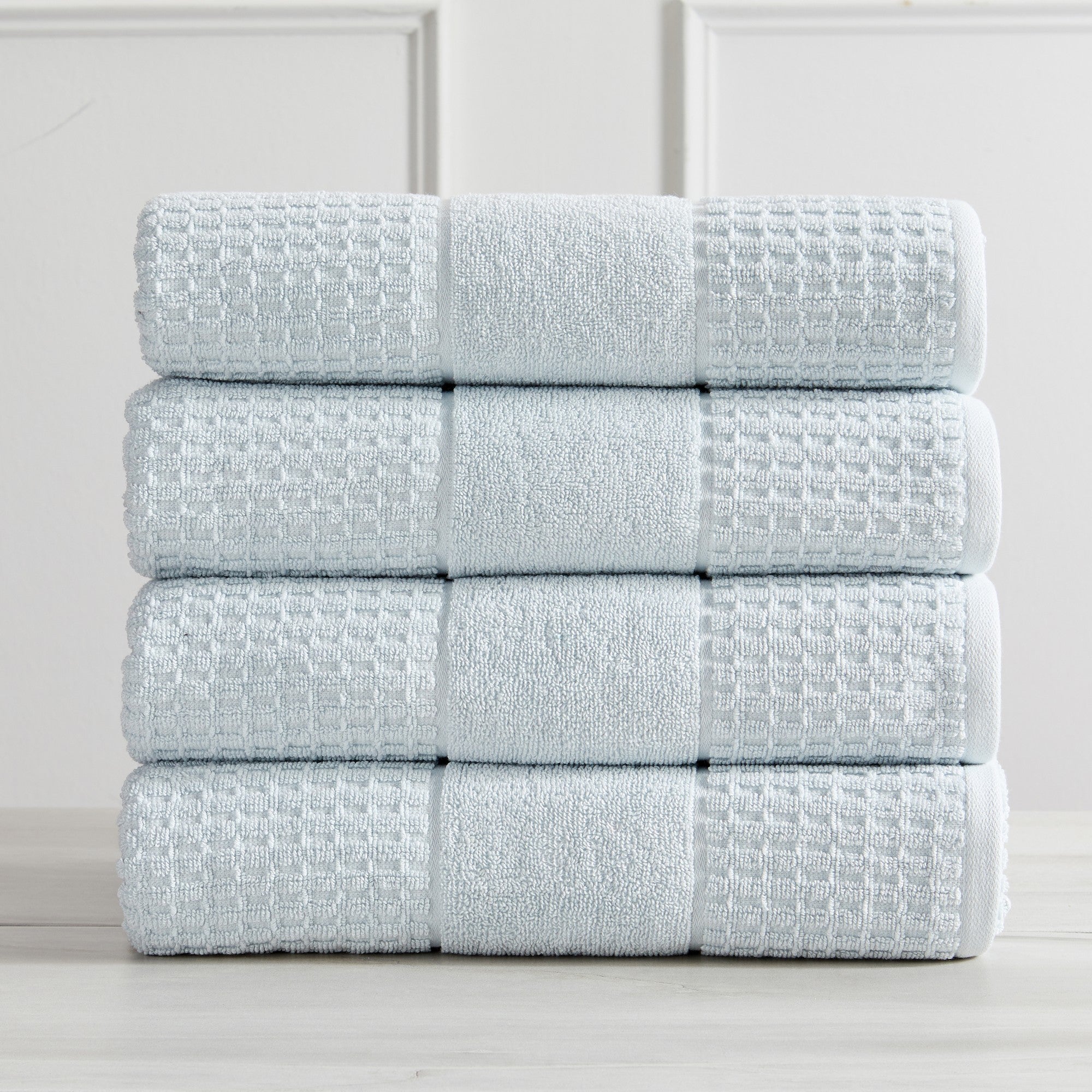 Harper Collection Waffle Textured Bath Towels by Market & Place featuring premium 100% cotton construction with a stylish waffle weave texture. Available in multiple colors and set configurations, including bath towels, hand towels, and washcloths, shown folded, stacked, and styled to highlight their soft, plush, and highly absorbent design.