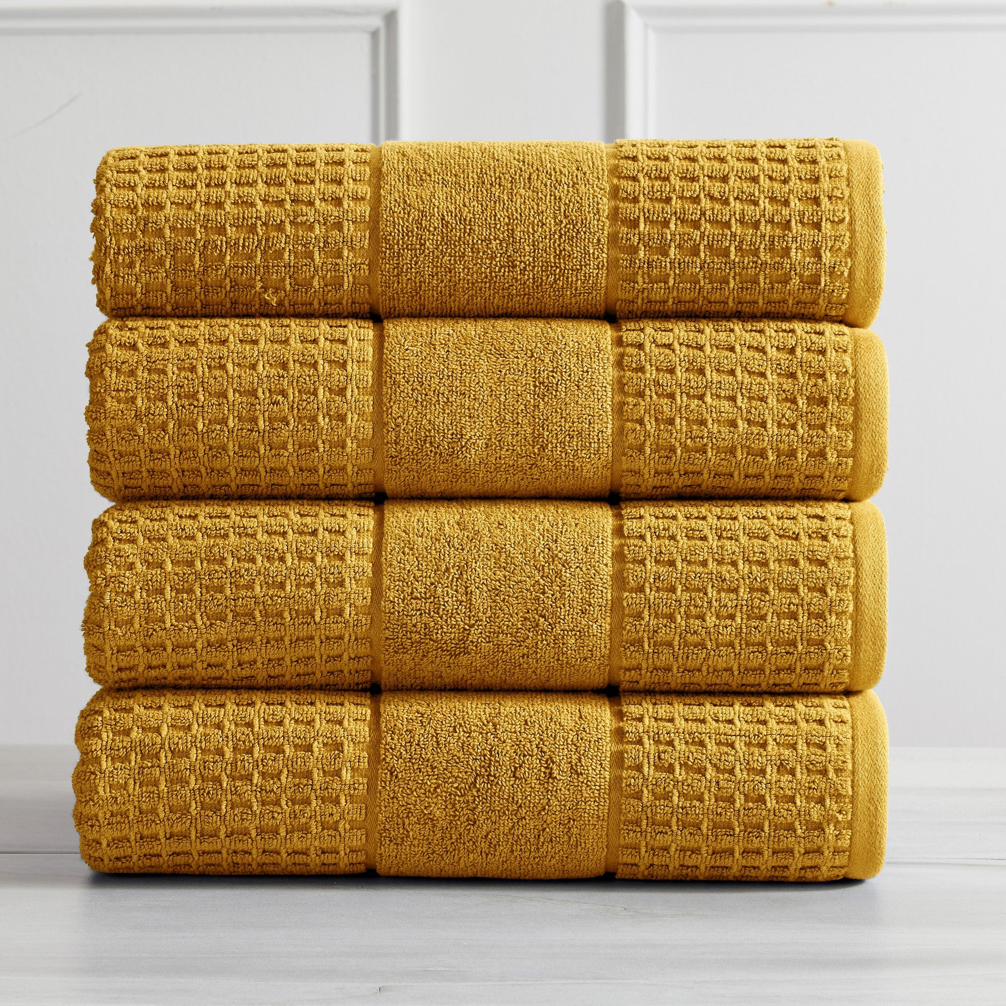 Harper Collection Waffle Textured Bath Towels by Market & Place featuring premium 100% cotton construction with a stylish waffle weave texture. Available in multiple colors and set configurations, including bath towels, hand towels, and washcloths, shown folded, stacked, and styled to highlight their soft, plush, and highly absorbent design.