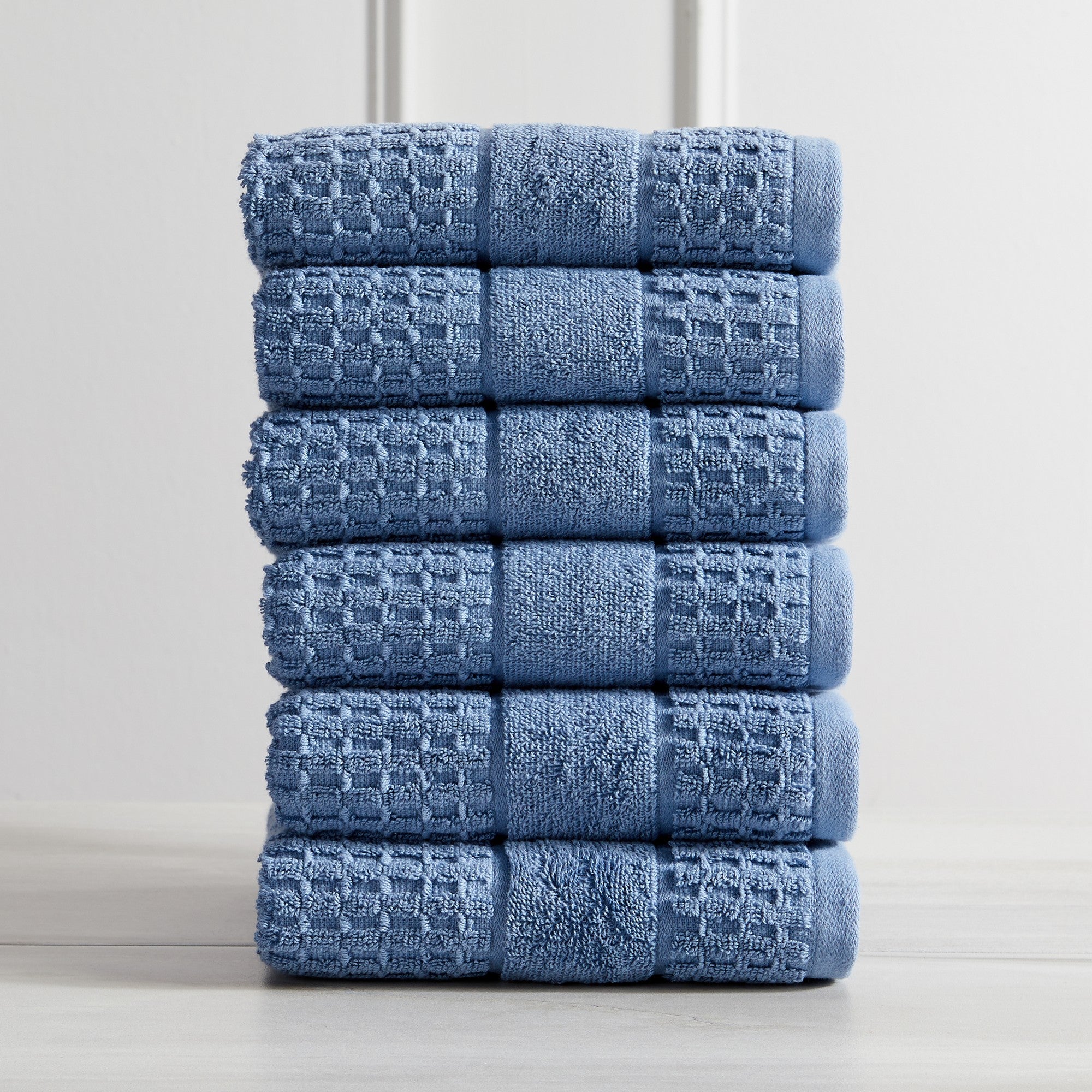Harper Collection Waffle Textured Bath Towels by Market & Place featuring premium 100% cotton construction with a stylish waffle weave texture. Available in multiple colors and set configurations, including bath towels, hand towels, and washcloths, shown folded, stacked, and styled to highlight their soft, plush, and highly absorbent design.