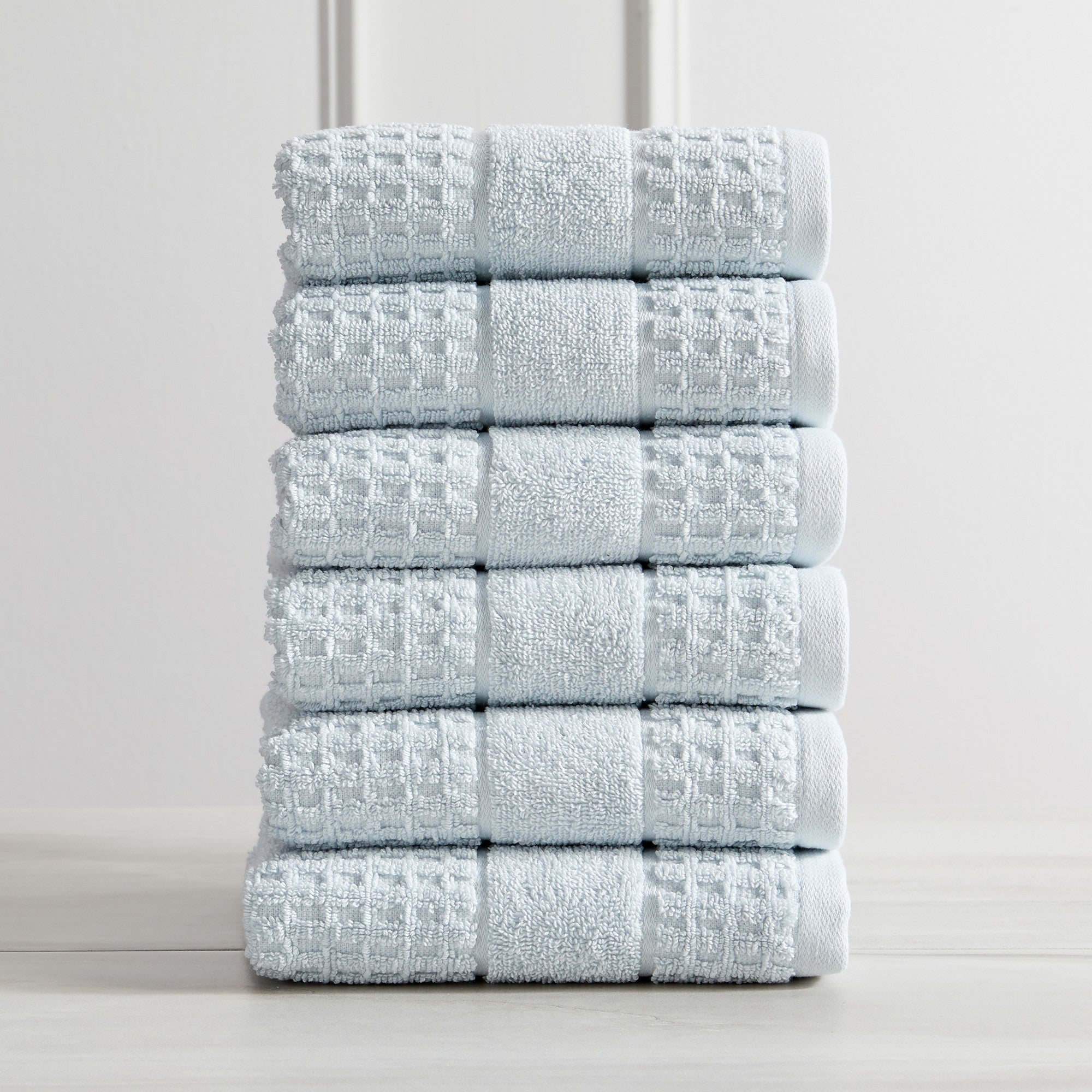 Harper Collection Waffle Textured Bath Towels by Market & Place featuring premium 100% cotton construction with a stylish waffle weave texture. Available in multiple colors and set configurations, including bath towels, hand towels, and washcloths, shown folded, stacked, and styled to highlight their soft, plush, and highly absorbent design.