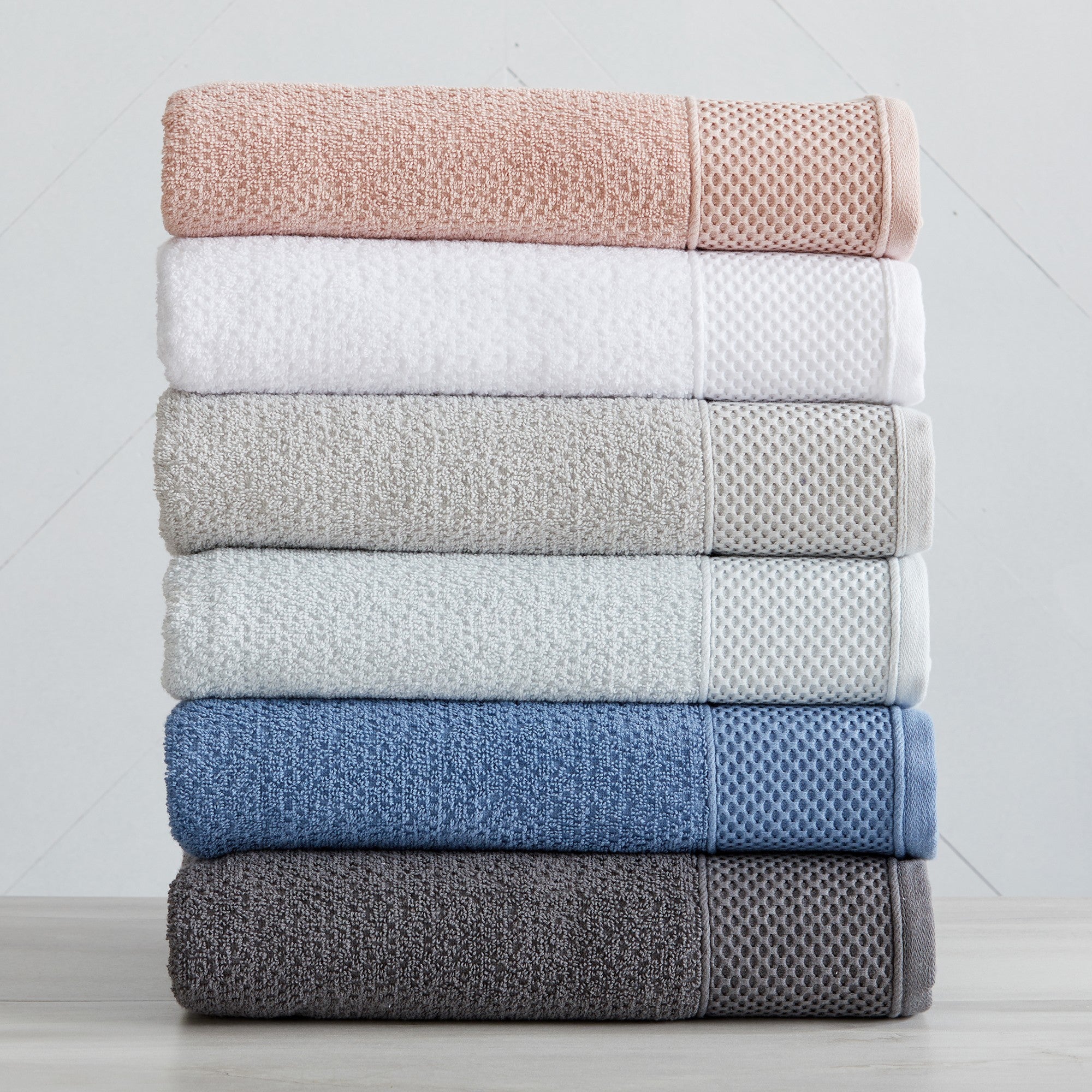 Soft and absorbent 100% cotton bath towel sets in assorted solid colors, featuring plush textures and coordinated bath towels, hand towels, and washcloths styled in bathroom and lifestyle settings.