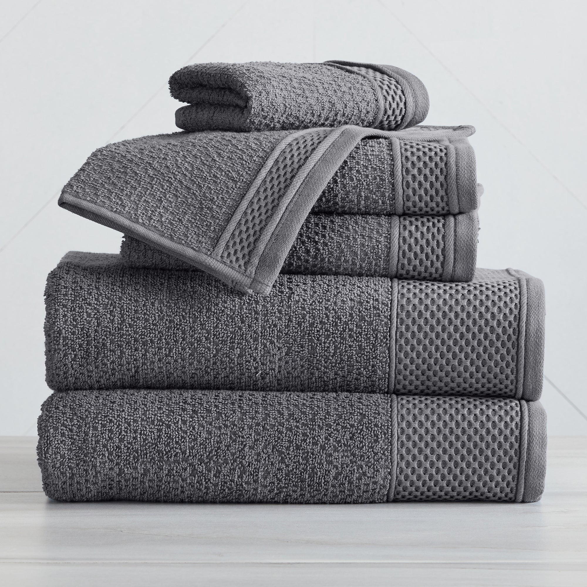 Soft and absorbent 100% cotton bath towel sets in assorted solid colors, featuring plush textures and coordinated bath towels, hand towels, and washcloths styled in bathroom and lifestyle settings.