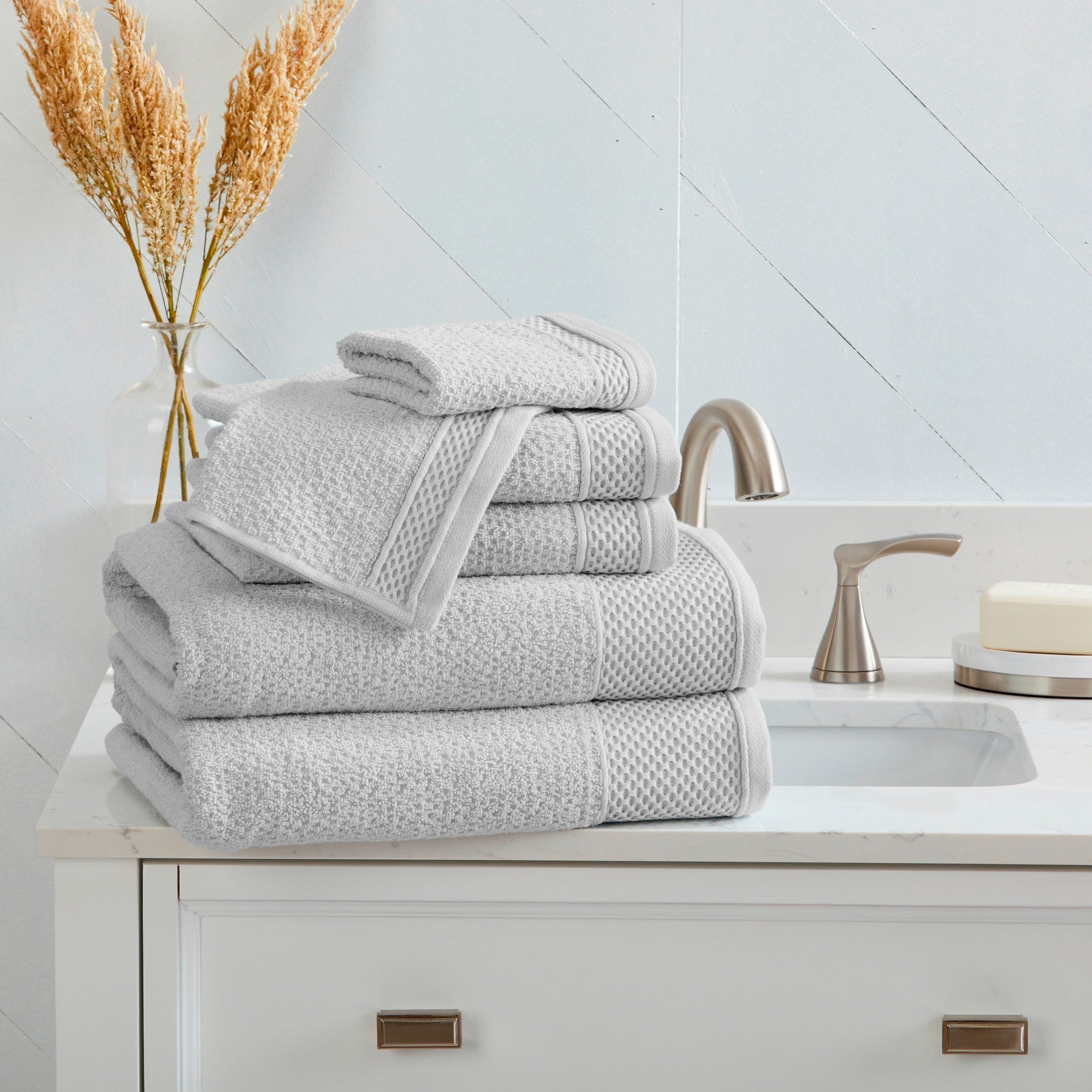 Soft and absorbent 100% cotton bath towel sets in assorted solid colors, featuring plush textures and coordinated bath towels, hand towels, and washcloths styled in bathroom and lifestyle settings.