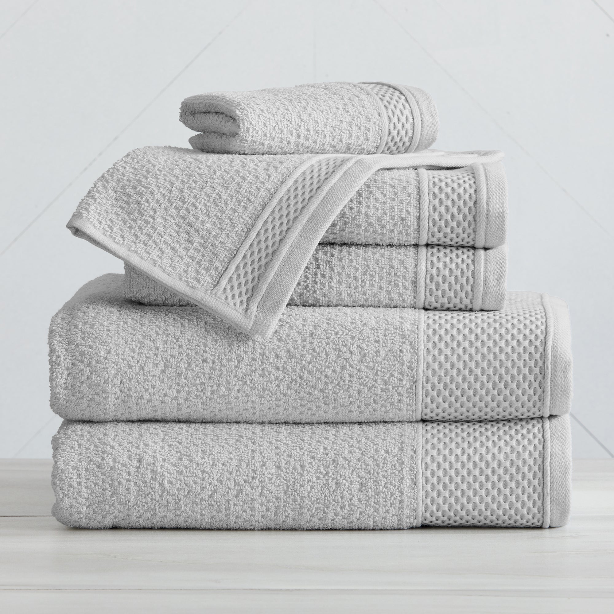 Soft and absorbent 100% cotton bath towel sets in assorted solid colors, featuring plush textures and coordinated bath towels, hand towels, and washcloths styled in bathroom and lifestyle settings.