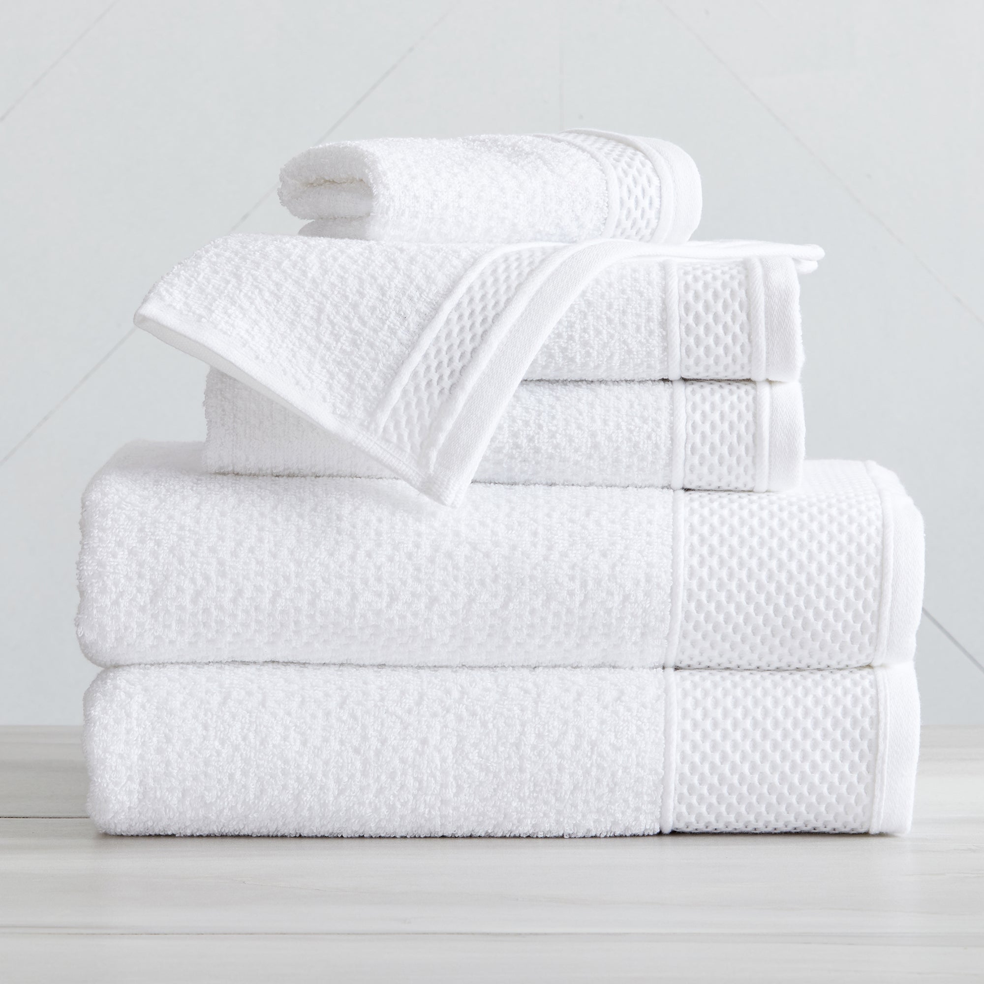 Soft and absorbent 100% cotton bath towel sets in assorted solid colors, featuring plush textures and coordinated bath towels, hand towels, and washcloths styled in bathroom and lifestyle settings.