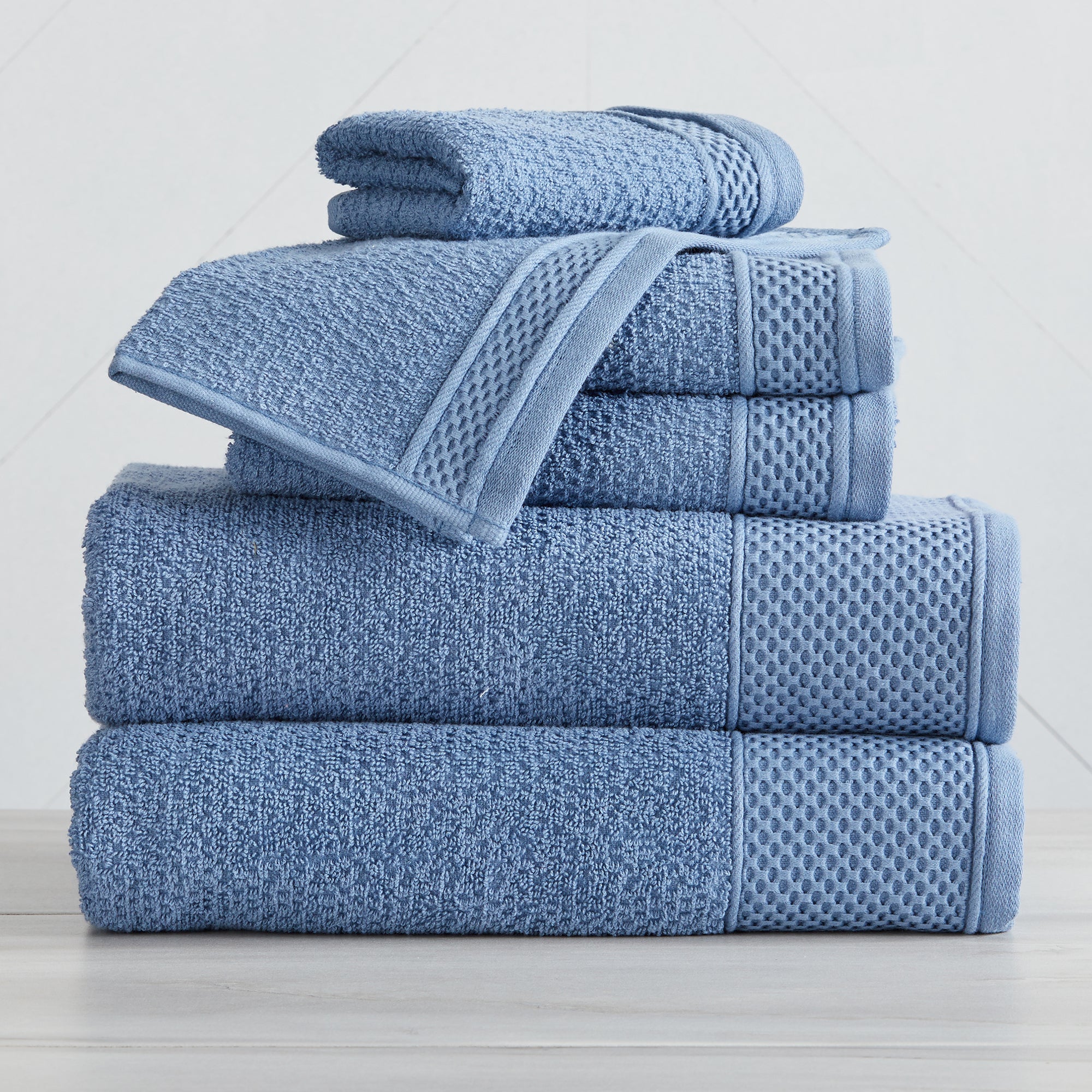 Soft and absorbent 100% cotton bath towel sets in assorted solid colors, featuring plush textures and coordinated bath towels, hand towels, and washcloths styled in bathroom and lifestyle settings.