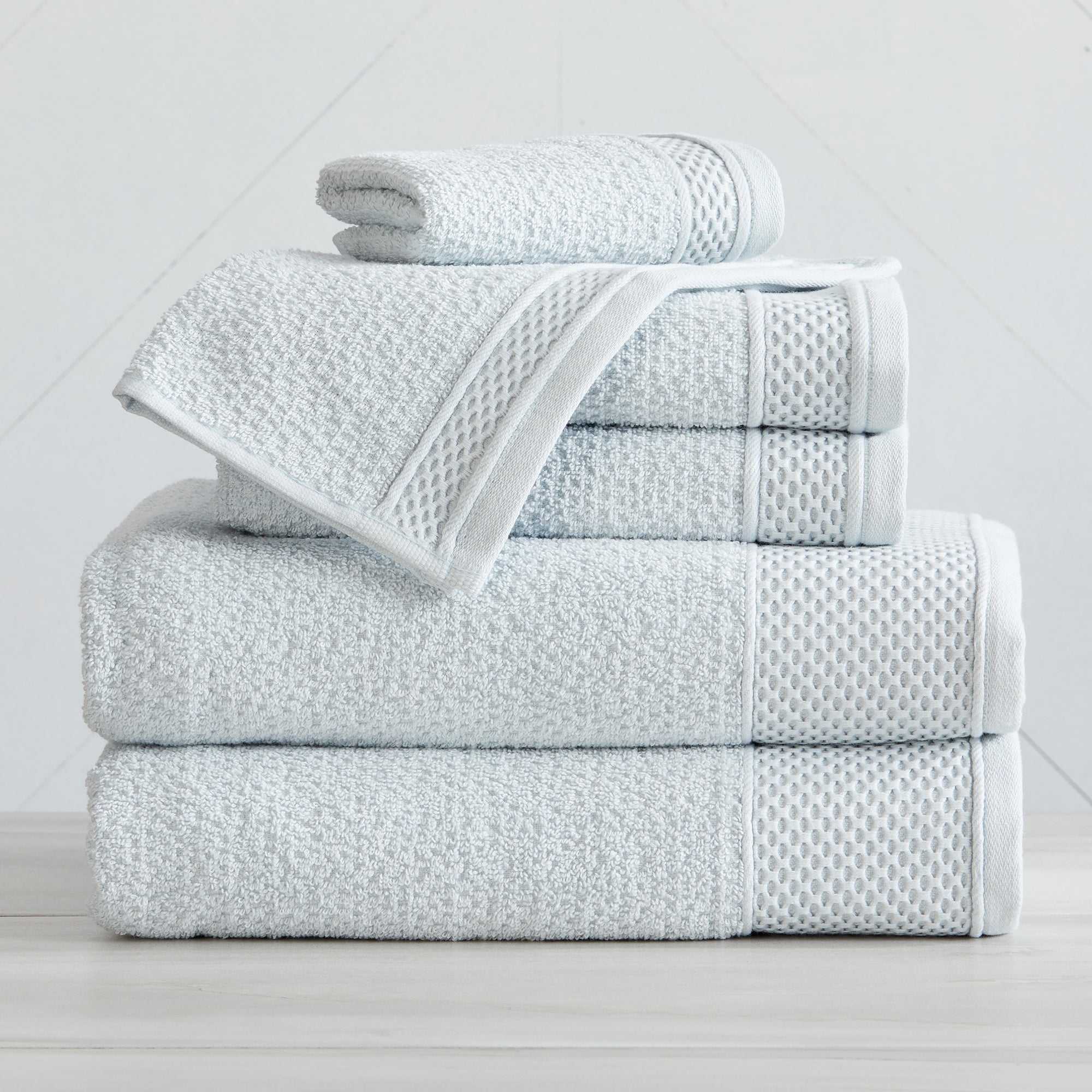 Soft and absorbent 100% cotton bath towel sets in assorted solid colors, featuring plush textures and coordinated bath towels, hand towels, and washcloths styled in bathroom and lifestyle settings.