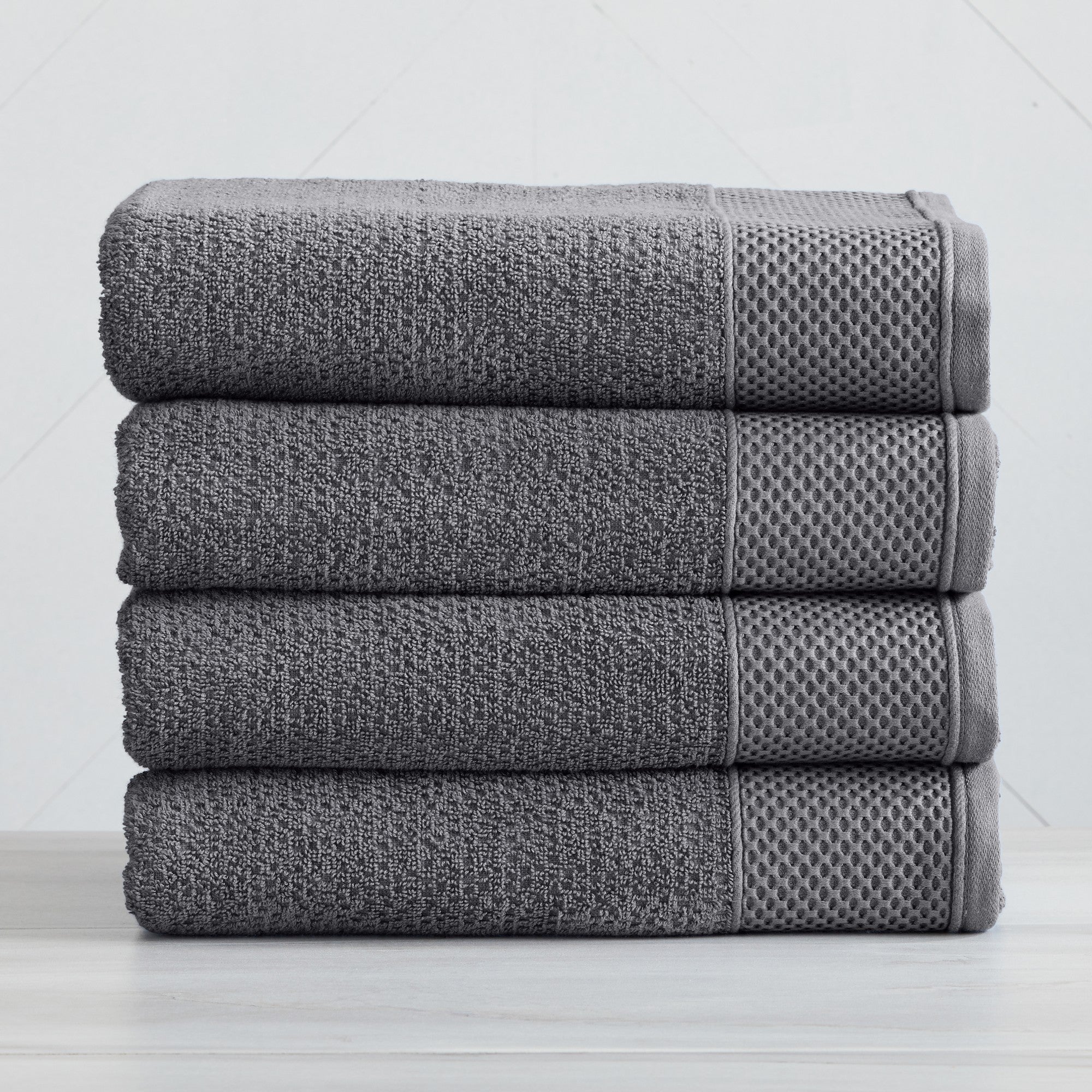 Soft and absorbent 100% cotton bath towel sets in assorted solid colors, featuring plush textures and coordinated bath towels, hand towels, and washcloths styled in bathroom and lifestyle settings.