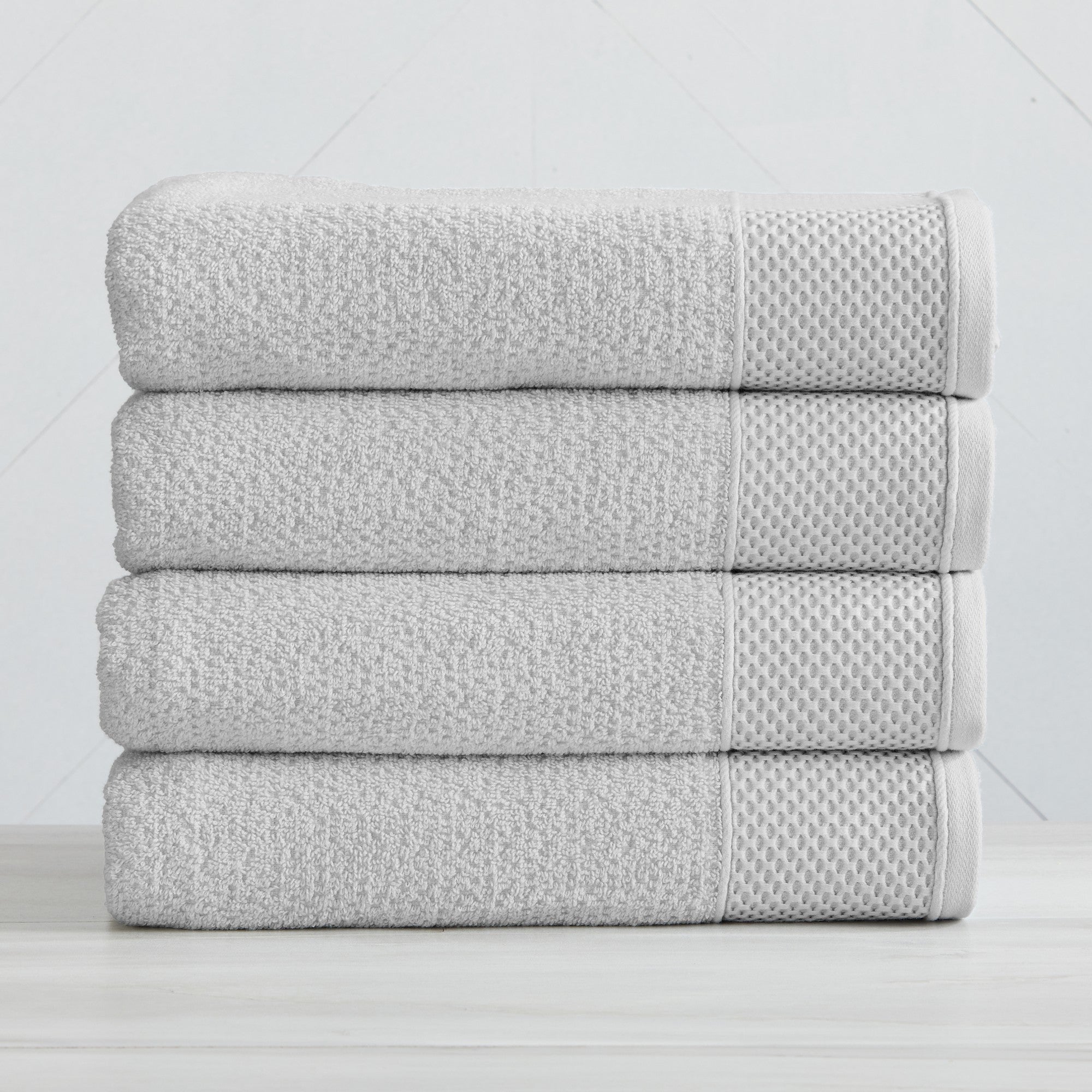 Soft and absorbent 100% cotton bath towel sets in assorted solid colors, featuring plush textures and coordinated bath towels, hand towels, and washcloths styled in bathroom and lifestyle settings.