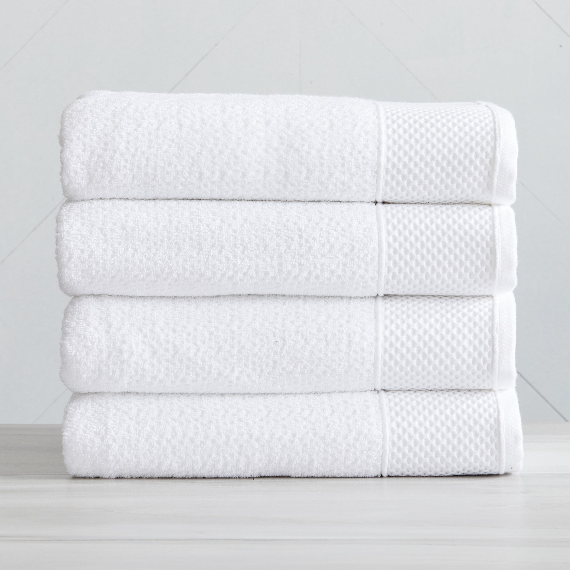 Soft and absorbent 100% cotton bath towel sets in assorted solid colors, featuring plush textures and coordinated bath towels, hand towels, and washcloths styled in bathroom and lifestyle settings.