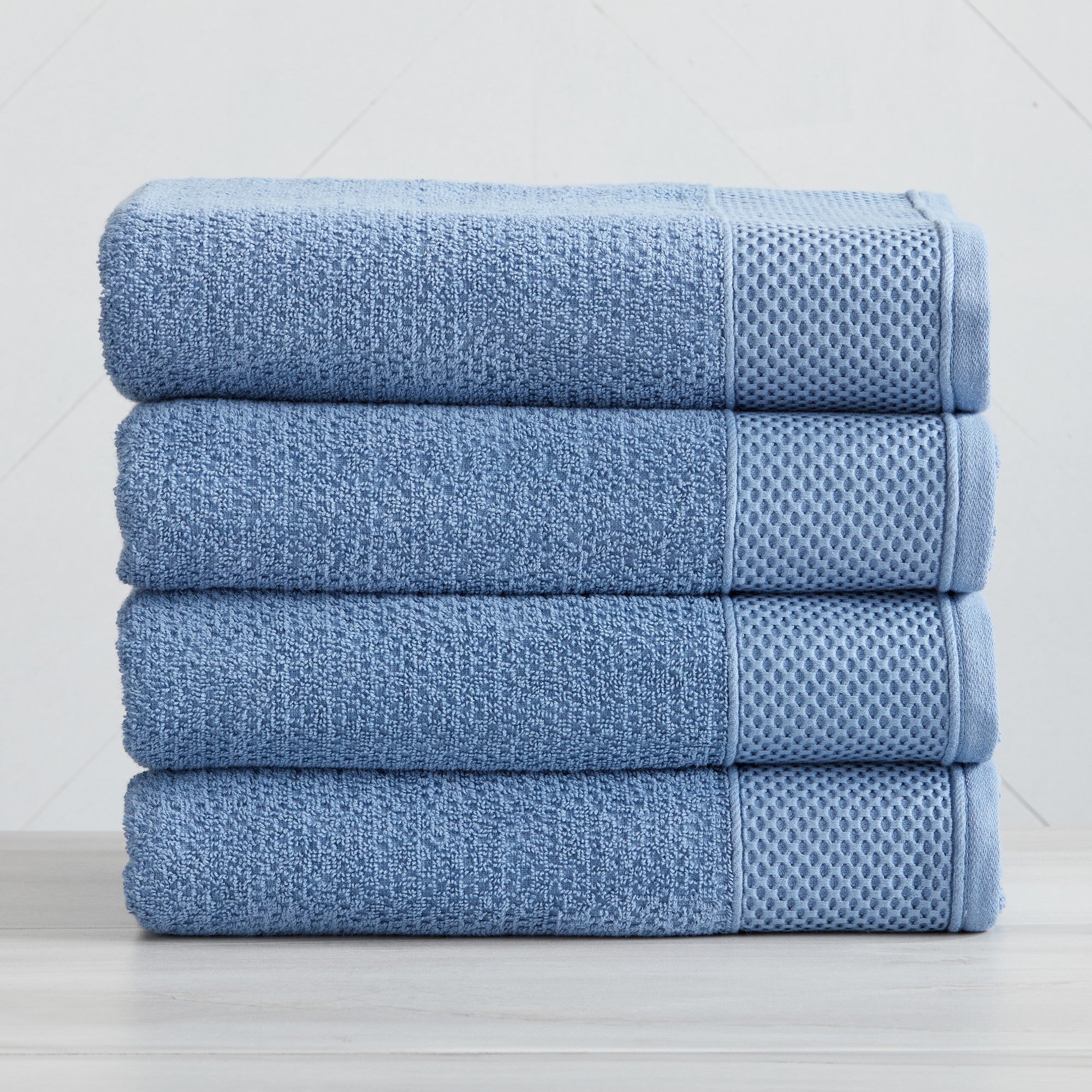 Soft and absorbent 100% cotton bath towel sets in assorted solid colors, featuring plush textures and coordinated bath towels, hand towels, and washcloths styled in bathroom and lifestyle settings.
