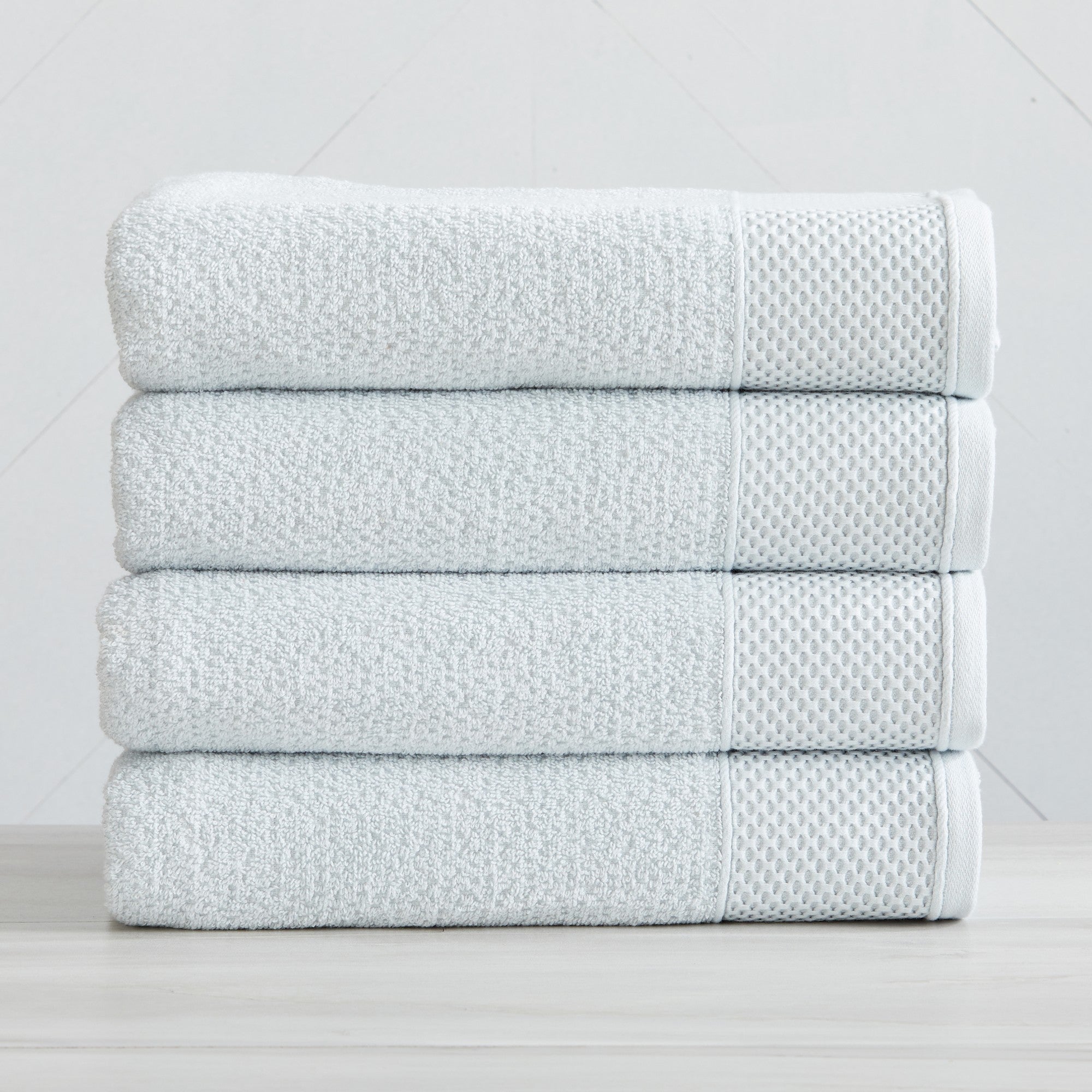 Soft and absorbent 100% cotton bath towel sets in assorted solid colors, featuring plush textures and coordinated bath towels, hand towels, and washcloths styled in bathroom and lifestyle settings.