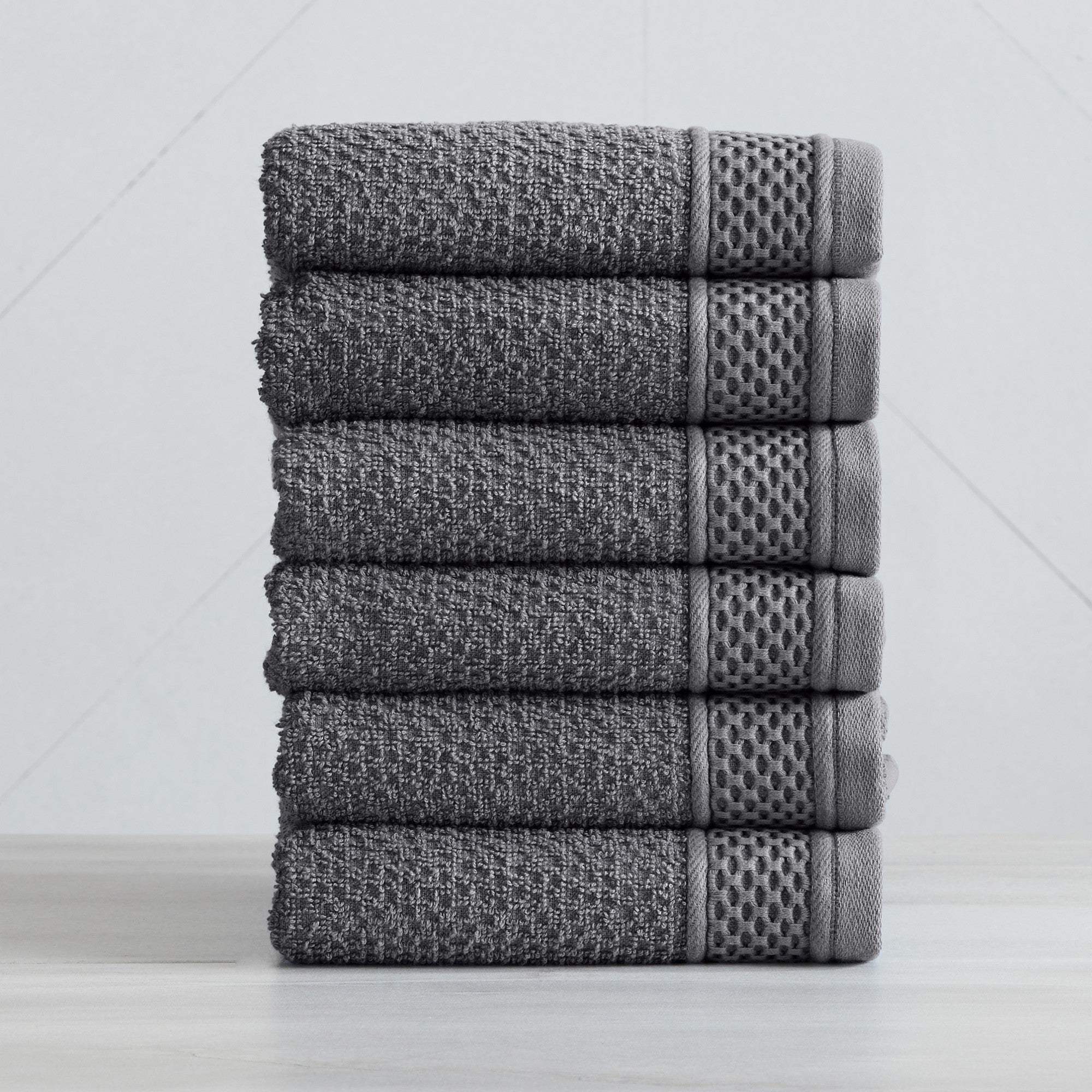 Soft and absorbent 100% cotton bath towel sets in assorted solid colors, featuring plush textures and coordinated bath towels, hand towels, and washcloths styled in bathroom and lifestyle settings.