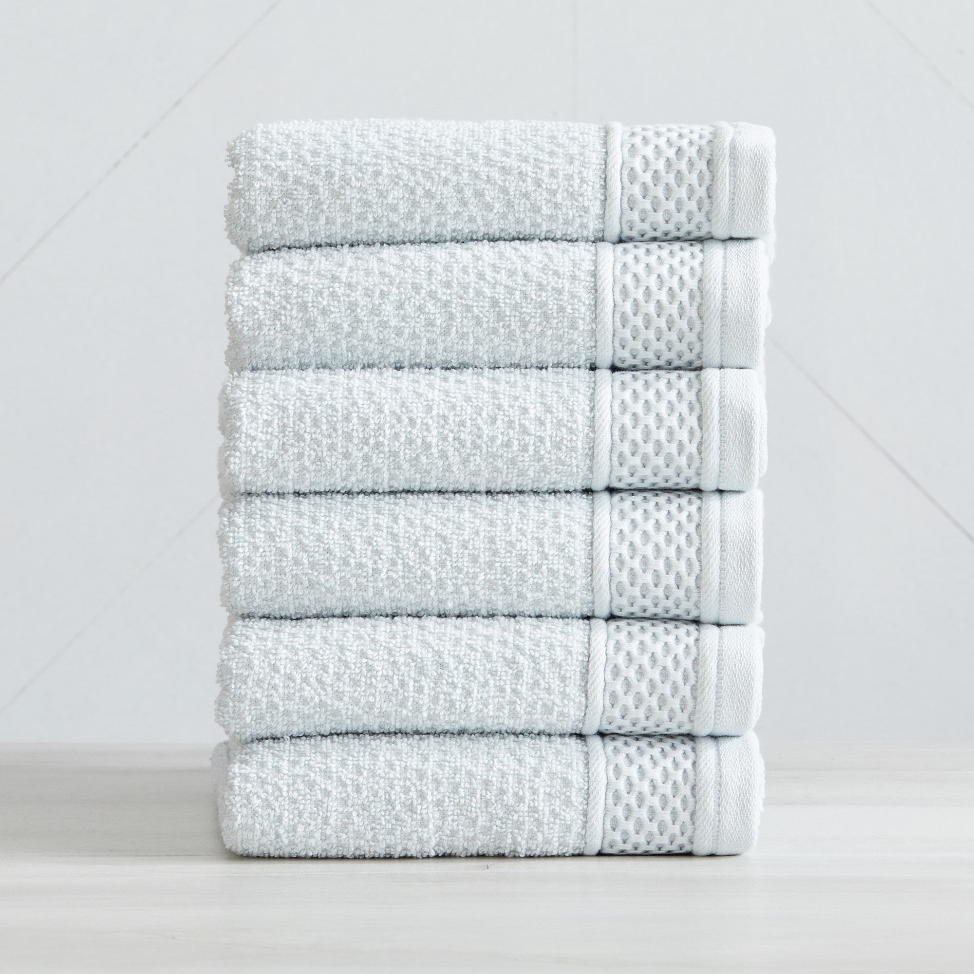 Soft and absorbent 100% cotton bath towel sets in assorted solid colors, featuring plush textures and coordinated bath towels, hand towels, and washcloths styled in bathroom and lifestyle settings.