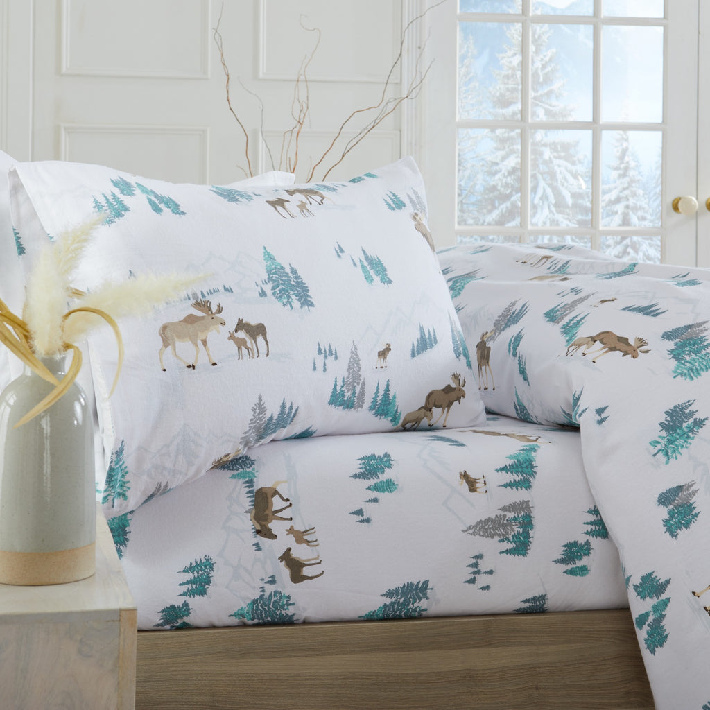 Printed 100% Turkish cotton flannel sheet set featuring assorted winter-inspired patterns, including woodland animals, snowflakes, trees, plaids, and seasonal motifs. Soft, cozy bedding shown in styled bedroom settings with close-up fabric details and folded sheet stacks in multiple designs.