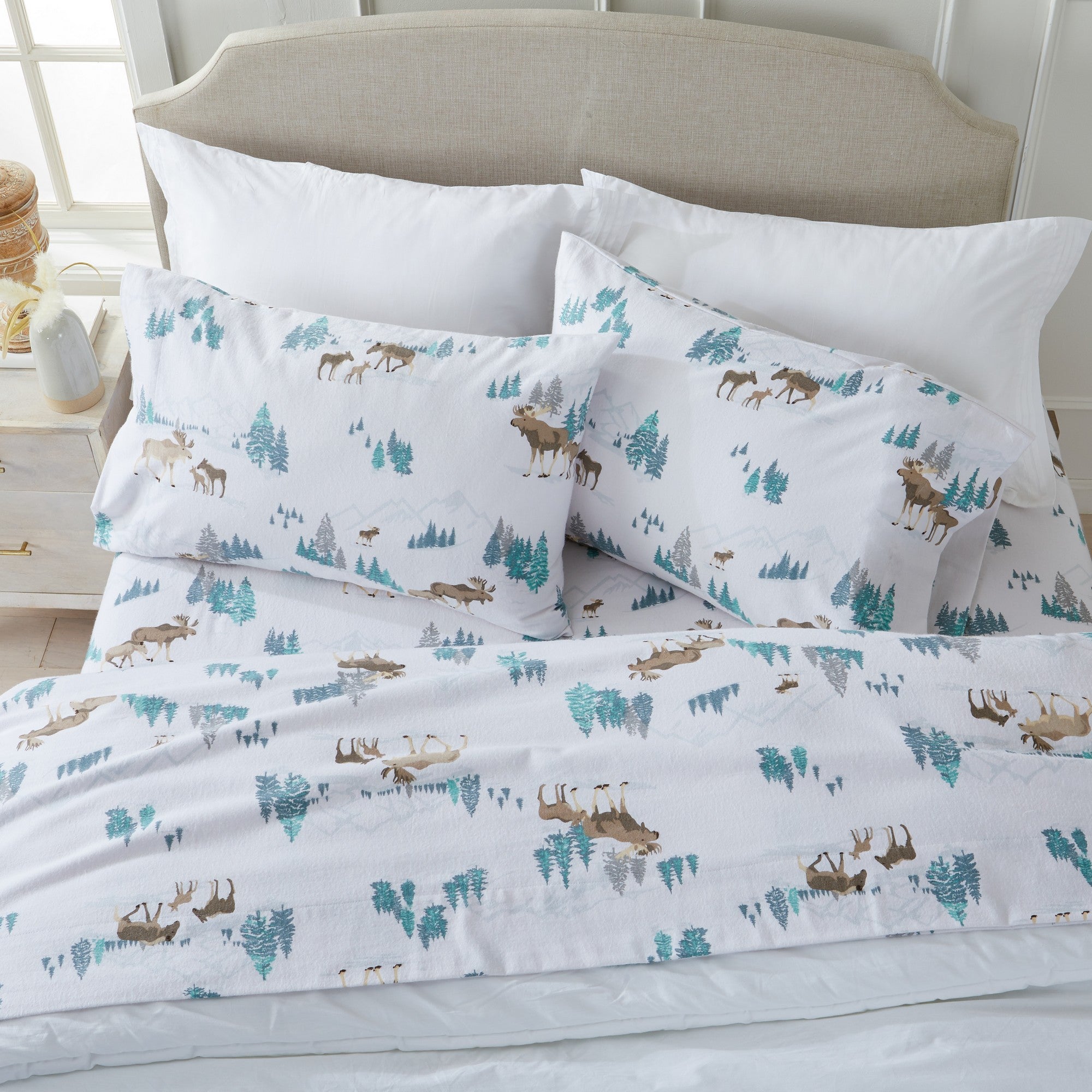 Printed 100% Turkish cotton flannel sheet set featuring assorted winter-inspired patterns, including woodland animals, snowflakes, trees, plaids, and seasonal motifs. Soft, cozy bedding shown in styled bedroom settings with close-up fabric details and folded sheet stacks in multiple designs.