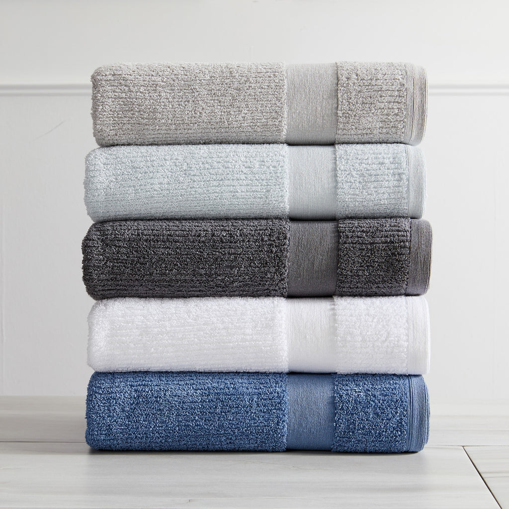 Roda Collection Cotton Ribbed Bath Towels by Market & Place featuring premium 100% cotton construction with a textured ribbed weave. Available in multiple colors and set configurations, including bath towels, hand towels, and washcloths, shown folded, stacked, and styled to highlight their soft, plush, and highly absorbent design.