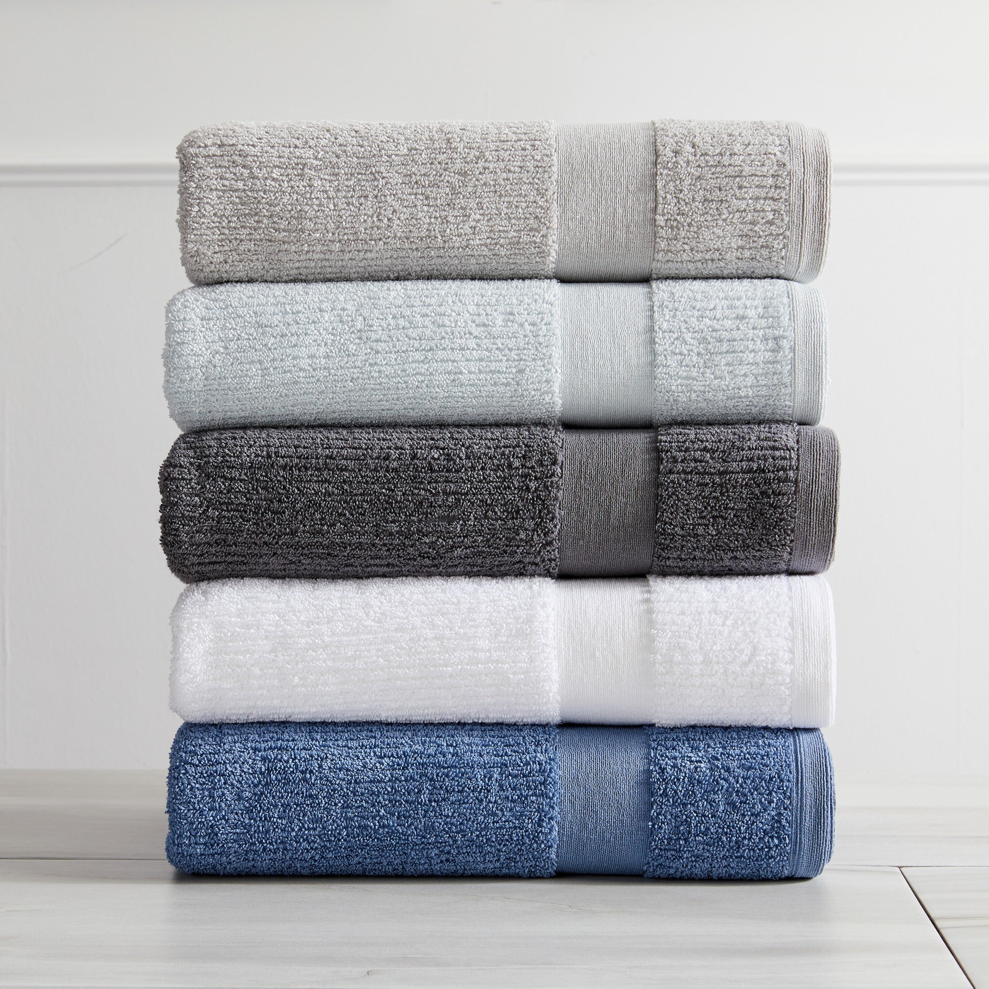 Roda Collection Cotton Ribbed Bath Towels by Market & Place featuring premium 100% cotton construction with a textured ribbed weave. Available in multiple colors and set configurations, including bath towels, hand towels, and washcloths, shown folded, stacked, and styled to highlight their soft, plush, and highly absorbent design.