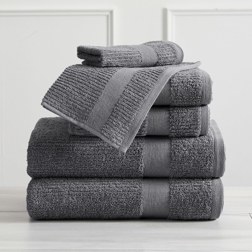 Roda Collection Cotton Ribbed Bath Towels by Market & Place featuring premium 100% cotton construction with a textured ribbed weave. Available in multiple colors and set configurations, including bath towels, hand towels, and washcloths, shown folded, stacked, and styled to highlight their soft, plush, and highly absorbent design.