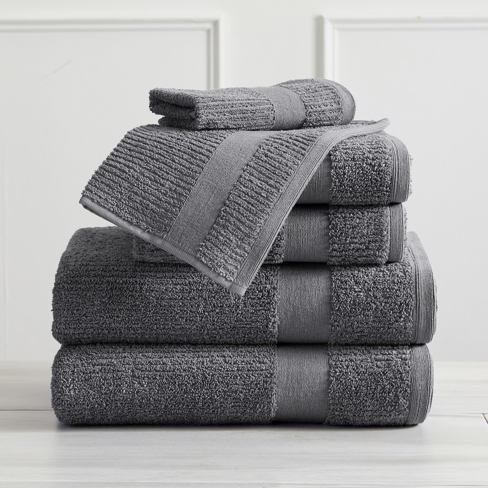 Roda Collection Cotton Ribbed Bath Towels by Market & Place featuring premium 100% cotton construction with a textured ribbed weave. Available in multiple colors and set configurations, including bath towels, hand towels, and washcloths, shown folded, stacked, and styled to highlight their soft, plush, and highly absorbent design.