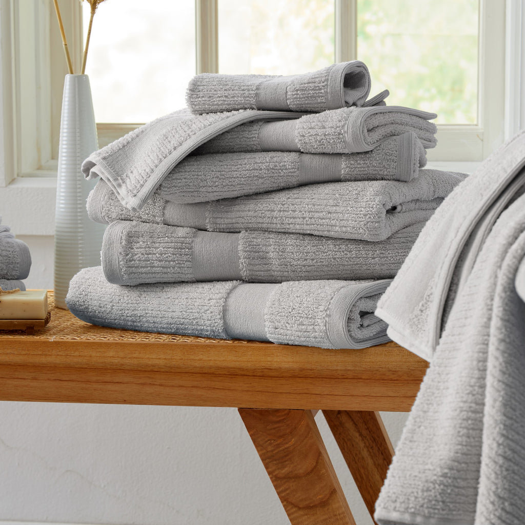 Roda Collection Cotton Ribbed Bath Towels by Market & Place featuring premium 100% cotton construction with a textured ribbed weave. Available in multiple colors and set configurations, including bath towels, hand towels, and washcloths, shown folded, stacked, and styled to highlight their soft, plush, and highly absorbent design.