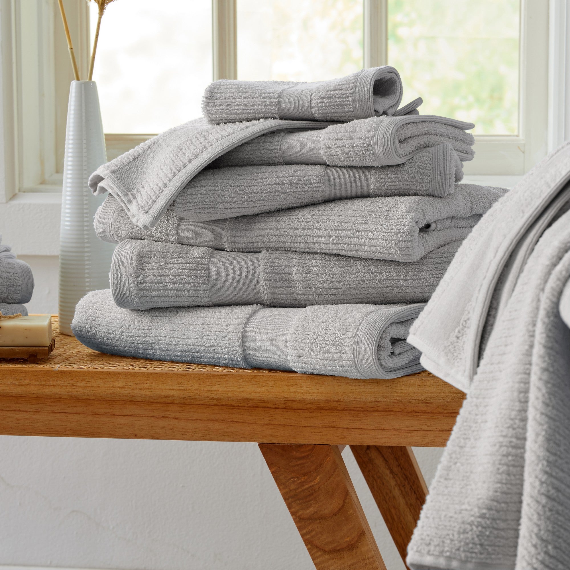Roda Collection Cotton Ribbed Bath Towels by Market & Place featuring premium 100% cotton construction with a textured ribbed weave. Available in multiple colors and set configurations, including bath towels, hand towels, and washcloths, shown folded, stacked, and styled to highlight their soft, plush, and highly absorbent design.