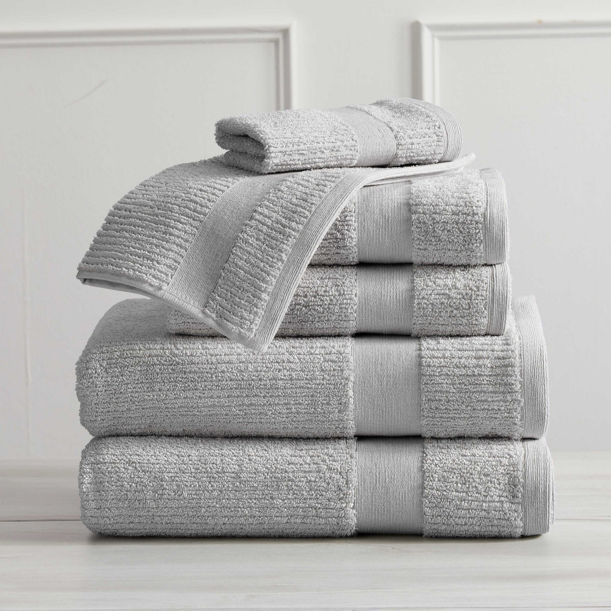 Roda Collection Cotton Ribbed Bath Towels by Market & Place featuring premium 100% cotton construction with a textured ribbed weave. Available in multiple colors and set configurations, including bath towels, hand towels, and washcloths, shown folded, stacked, and styled to highlight their soft, plush, and highly absorbent design.